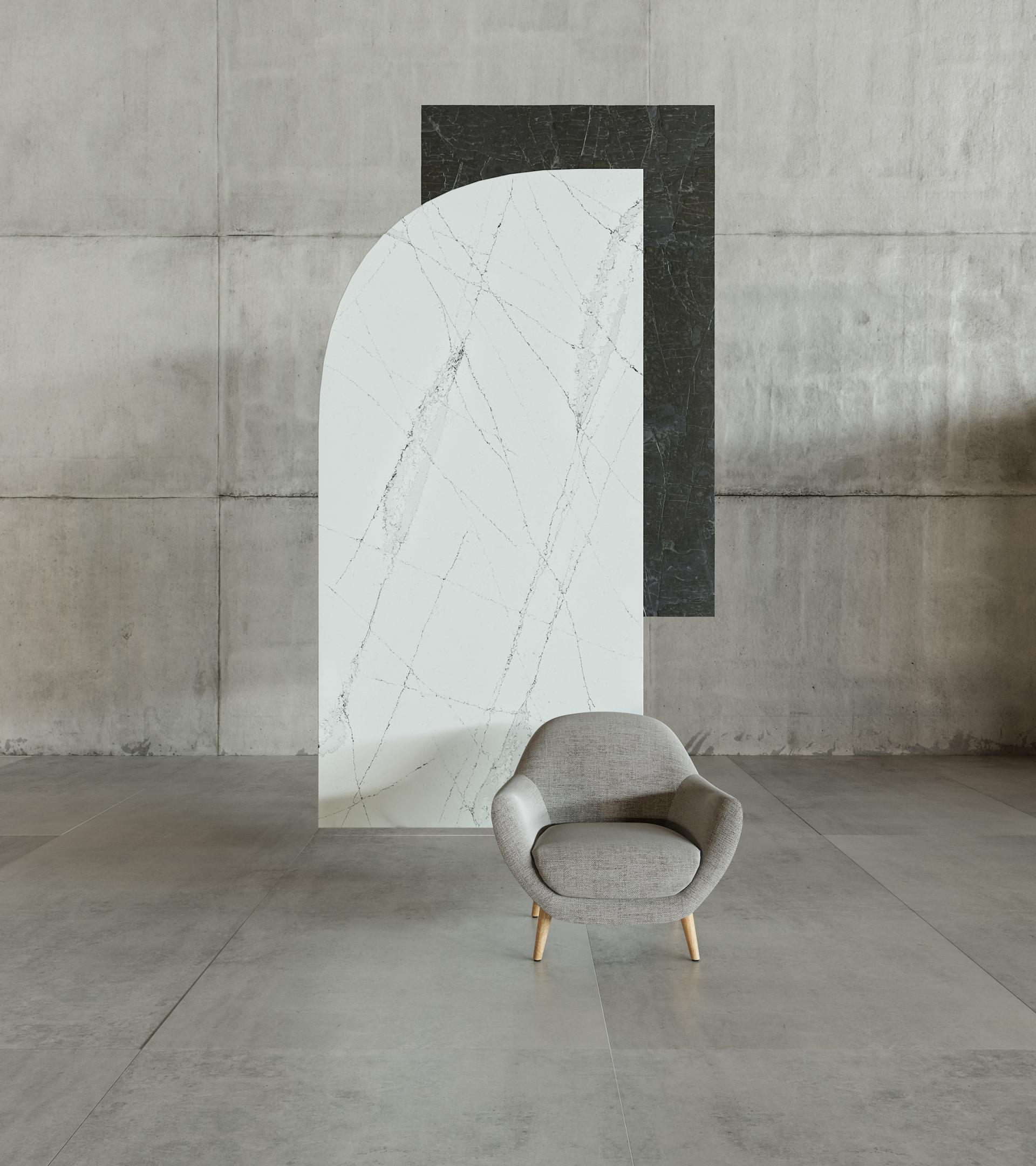Stylish contemporary space featuring a gray armchair against a backdrop of Silestone® Ethereal marble-look surfaces.