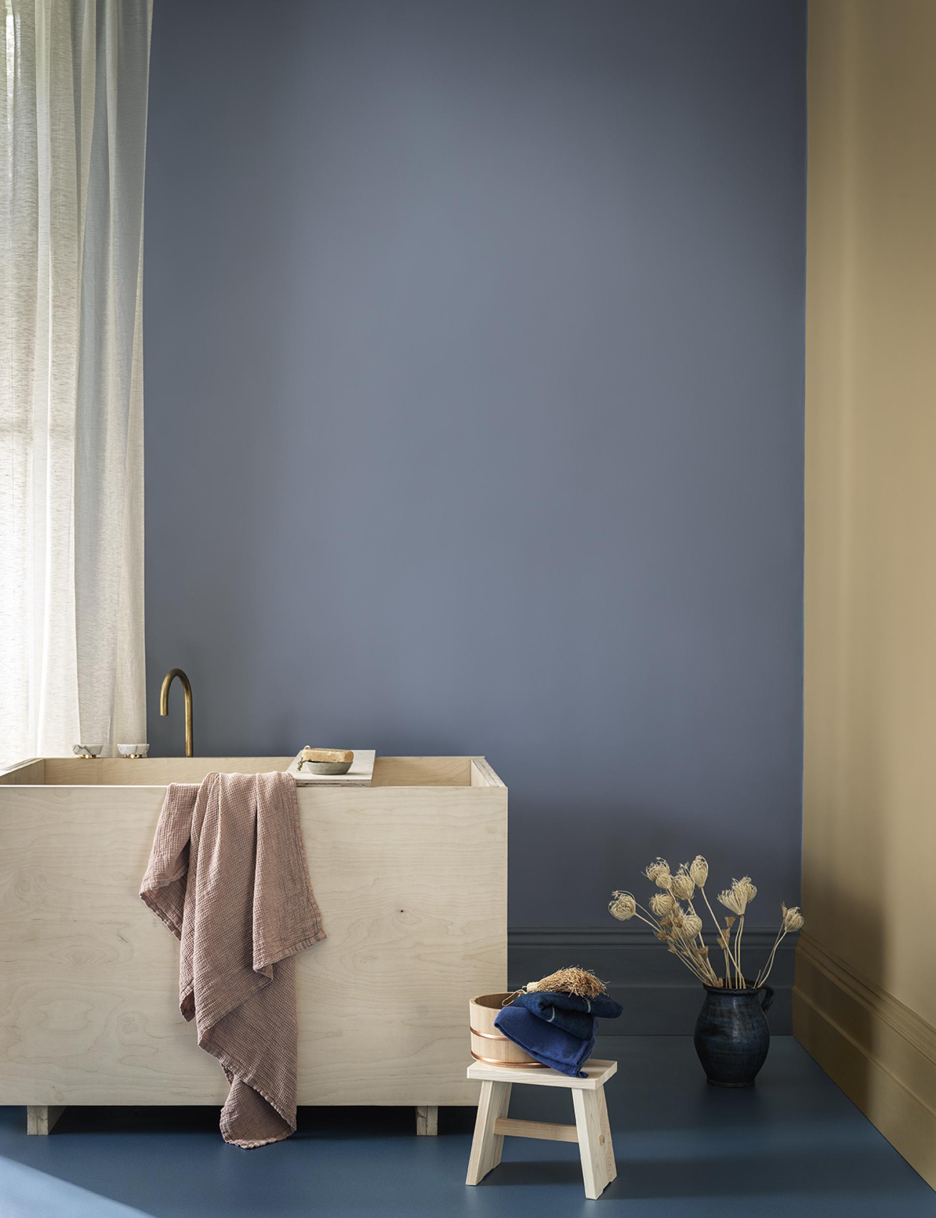 Elegant bathroom showcasing soothing SS22 color trends with a wooden tub, textured towels, and minimalist decor.