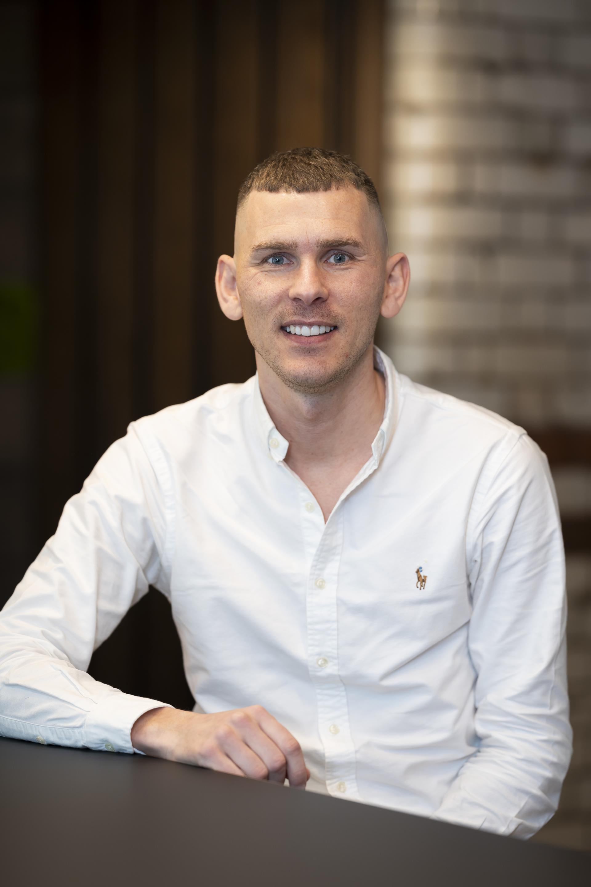 Professional man in a white shirt discussing technology's role in promoting sustainability in design.