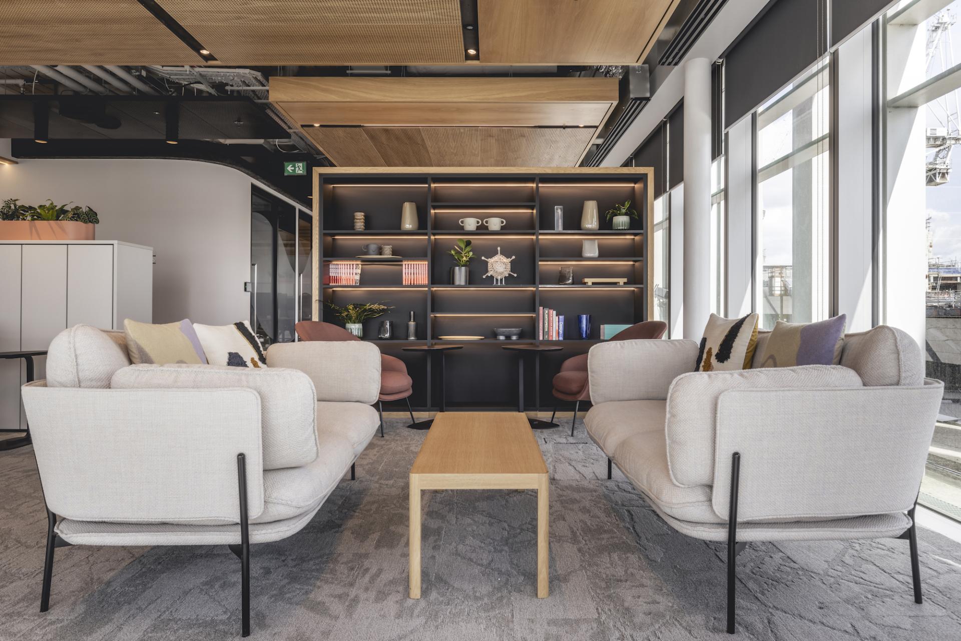Modern workspace featuring stylish seating and a decorative shelf, designed by Ekho Studio for AstraZeneca UK's office.