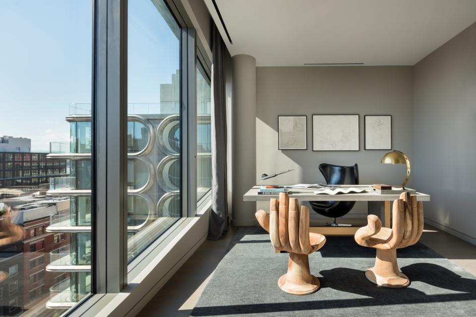 Contemporary penthouse office designed by Zaha Hadid featuring unique wooden chairs and expansive windows with city views.