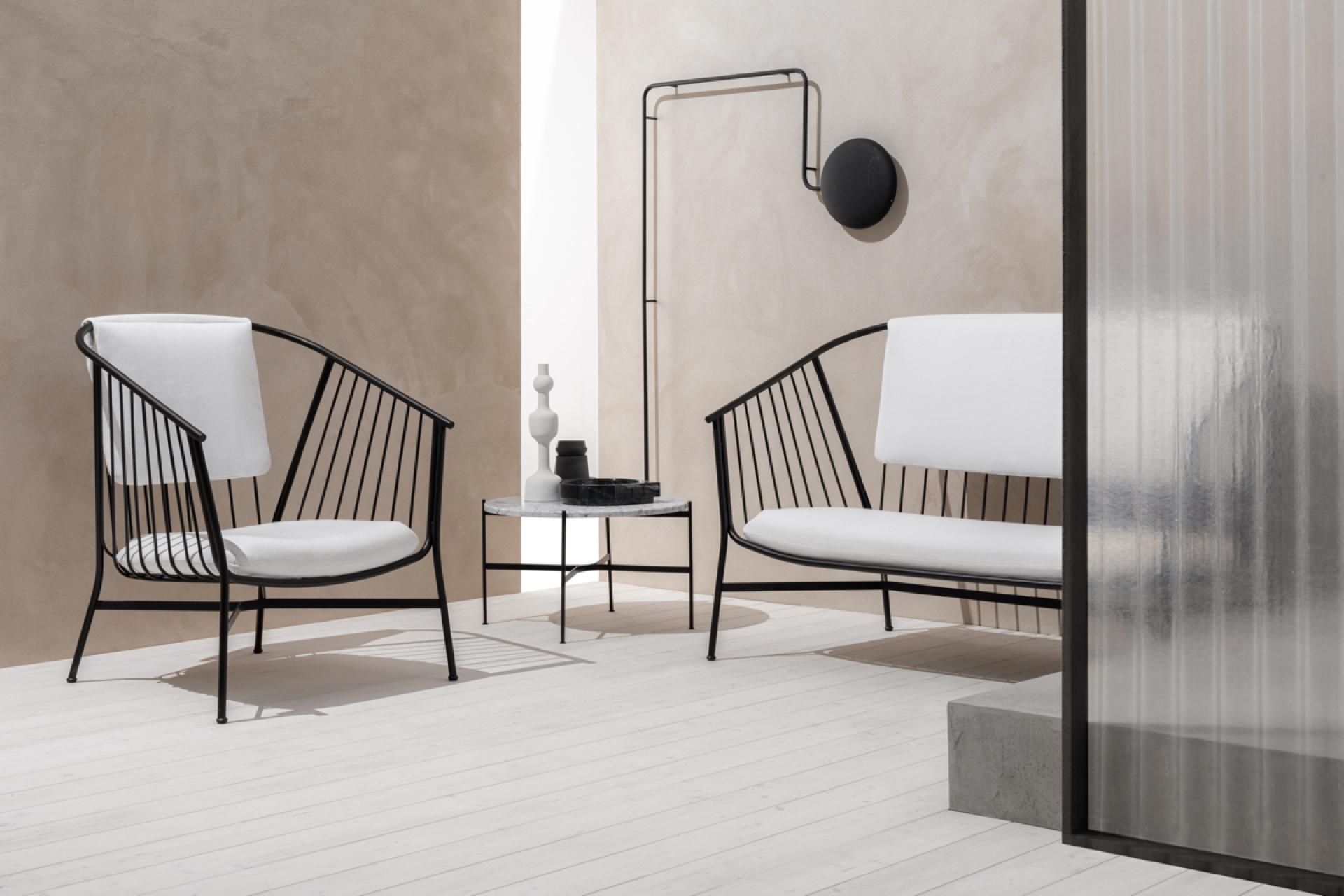 Contemporary outdoor seating by SP01, featuring wireframe chairs and a sleek side table in a minimalist setting.