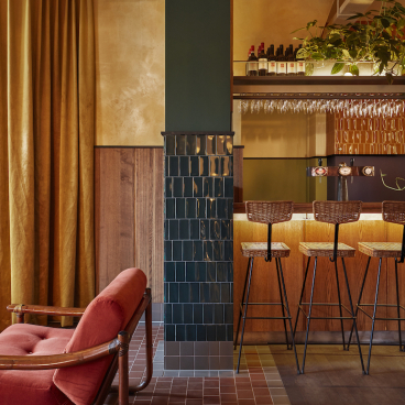 Stylish interior of Karavaan bar in Amsterdam, featuring a cozy lounge area and modern seating at the bar.
