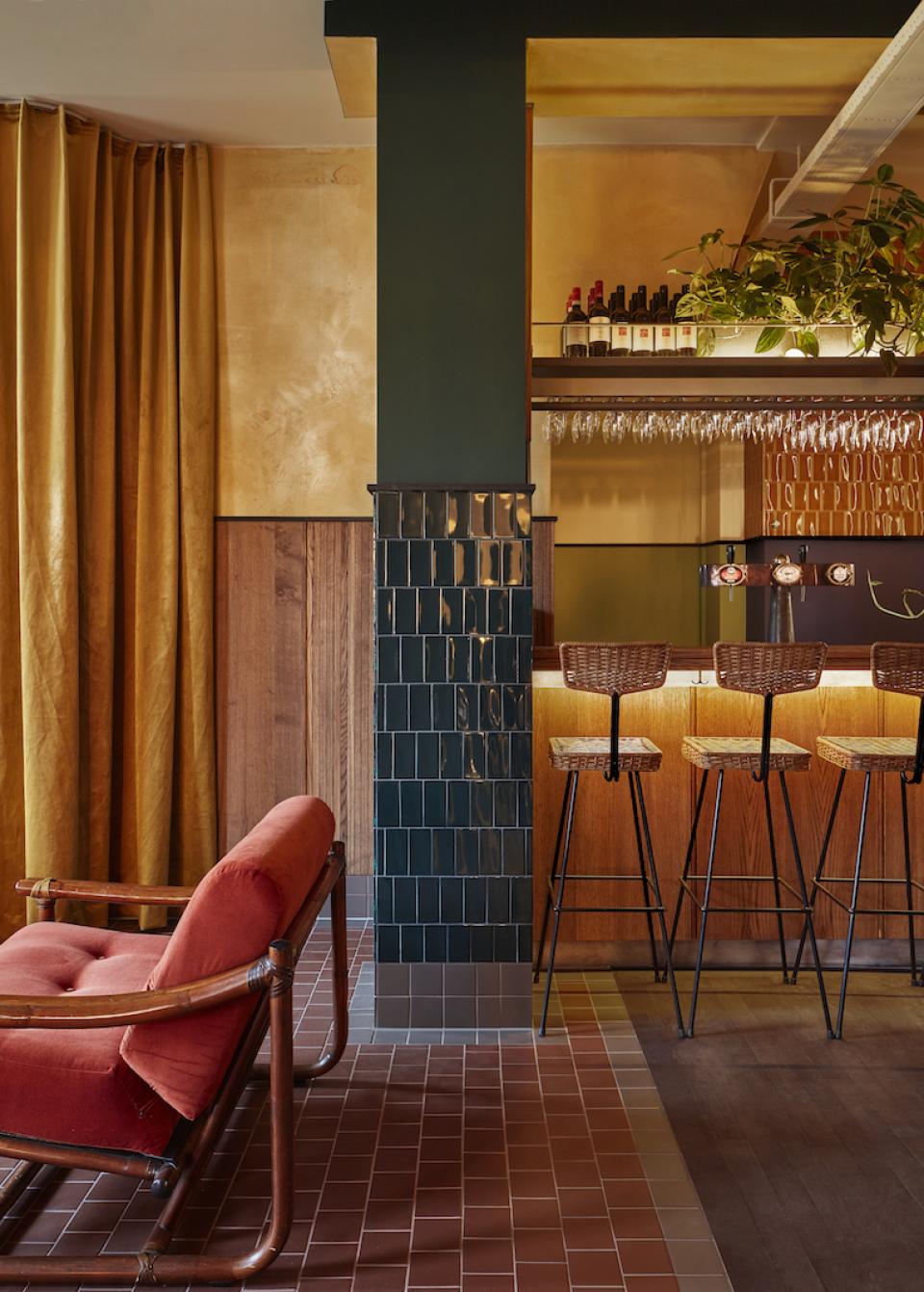 Stylish interior of Karavaan bar in Amsterdam, featuring a cozy lounge area and modern seating at the bar.