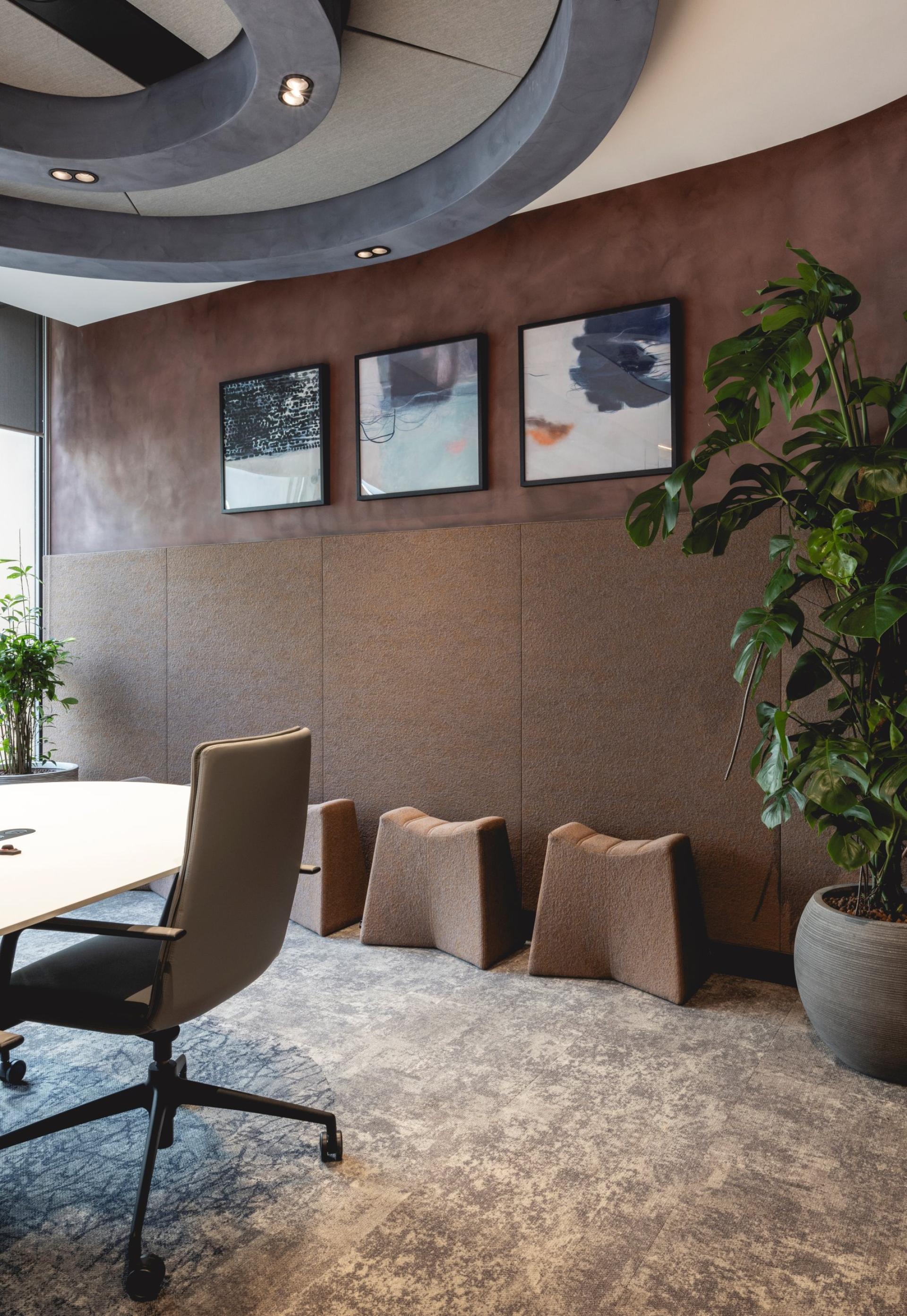 Stylish workspace featuring Art Deco-inspired curves, plants, artwork, and modern furniture elements in a calming atmosphere.