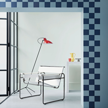 Stylish interior featuring blue checkered wall design, modern chair, and vibrant decor in a pastel setting.