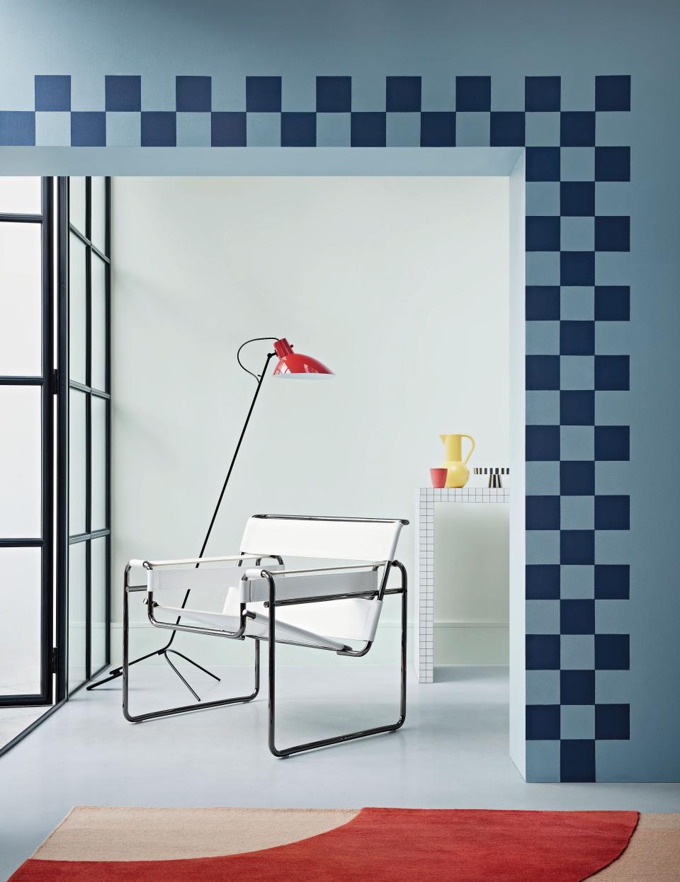 Stylish interior featuring blue checkered wall design, modern chair, and vibrant decor in a pastel setting.