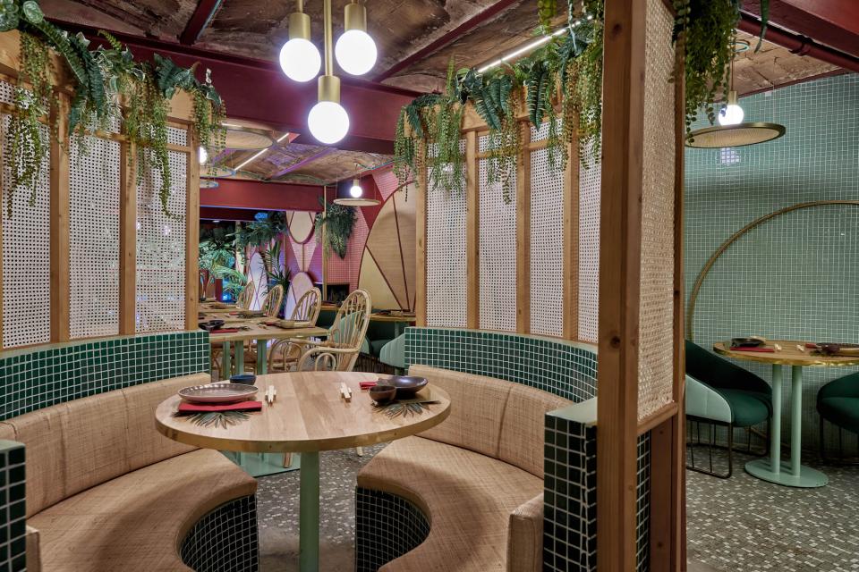 Lush interiors of Kaikaya, Valencia's tropical sushi restaurant, featuring natural materials, greenery, and modern design elements.