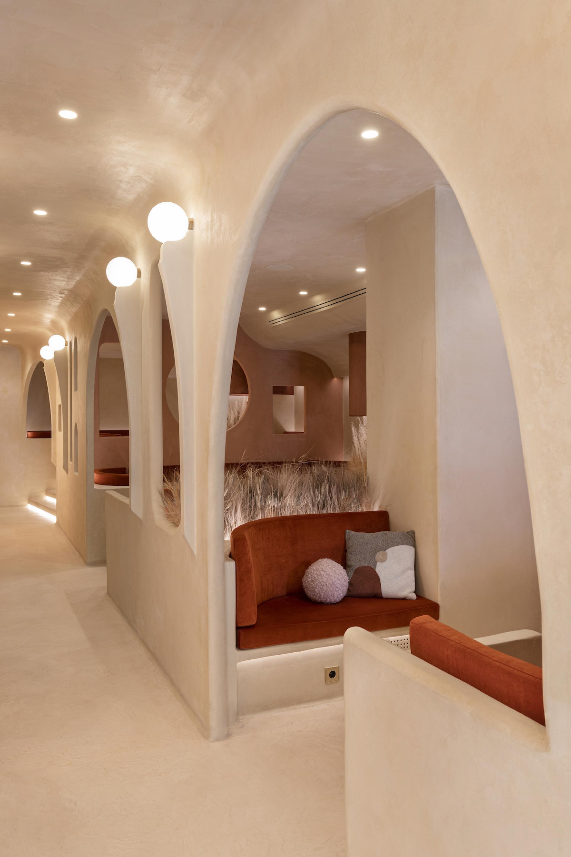 Modern interior of Living Bakkali restaurant in Valencia showcasing arches, cozy seating, and warm Middle Eastern design elements.