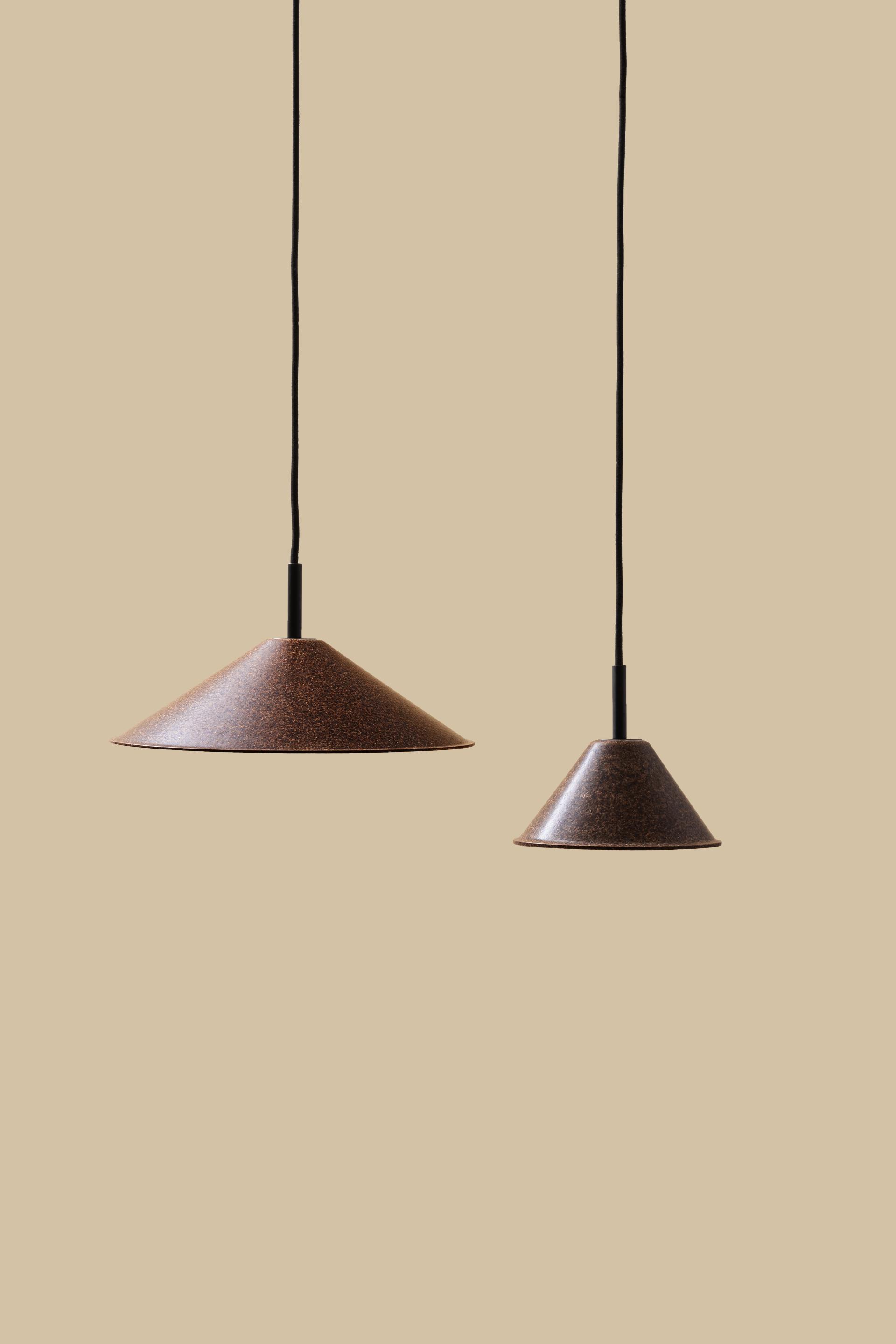 Rustic brown pendant lamps hang against a muted beige background, showcasing sustainable Italian design by High Society.