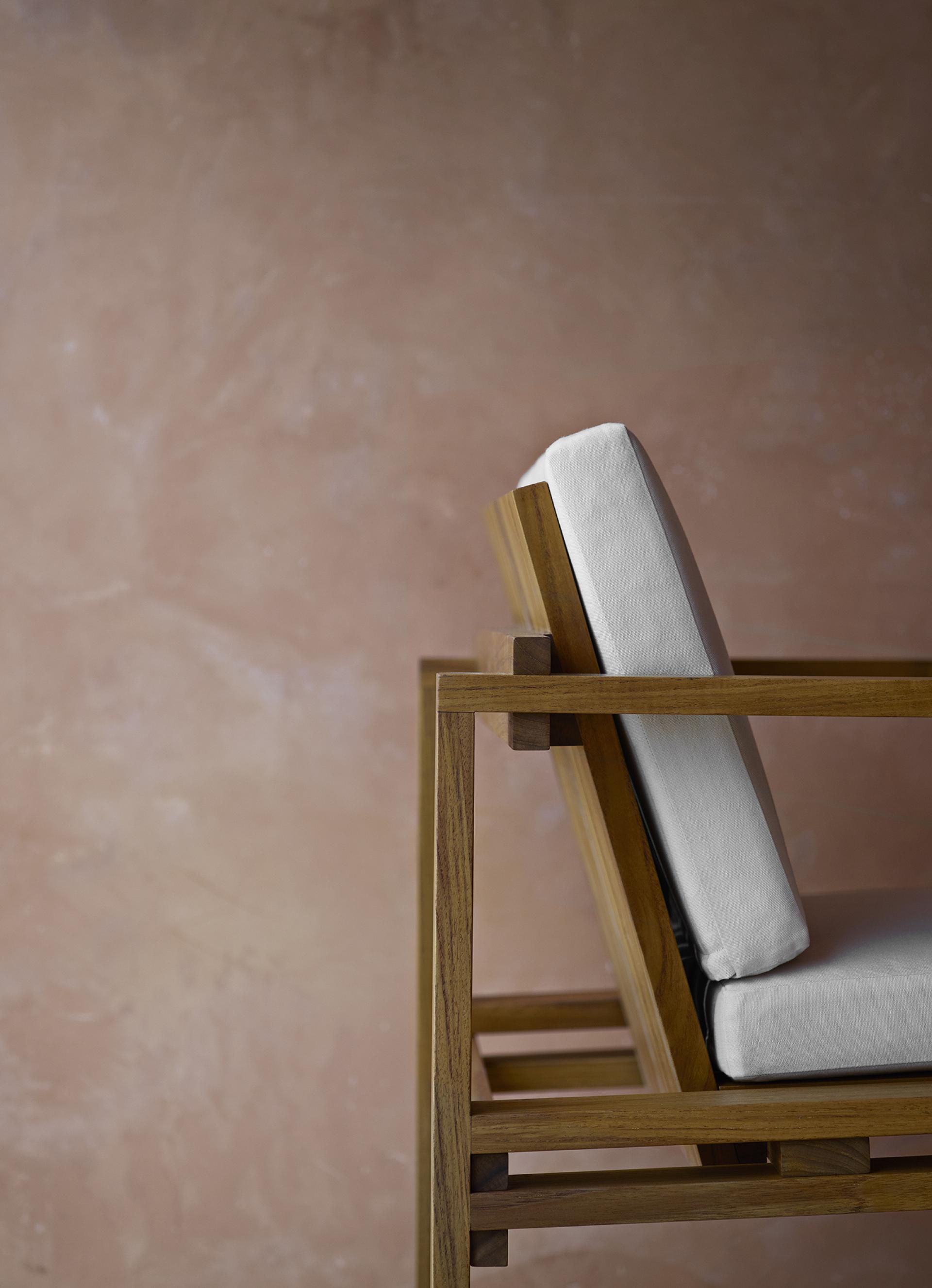 Bodil Kjær's architectural chair design showcased against a textured pink wall, highlighting its modern elegance and craftsmanship.