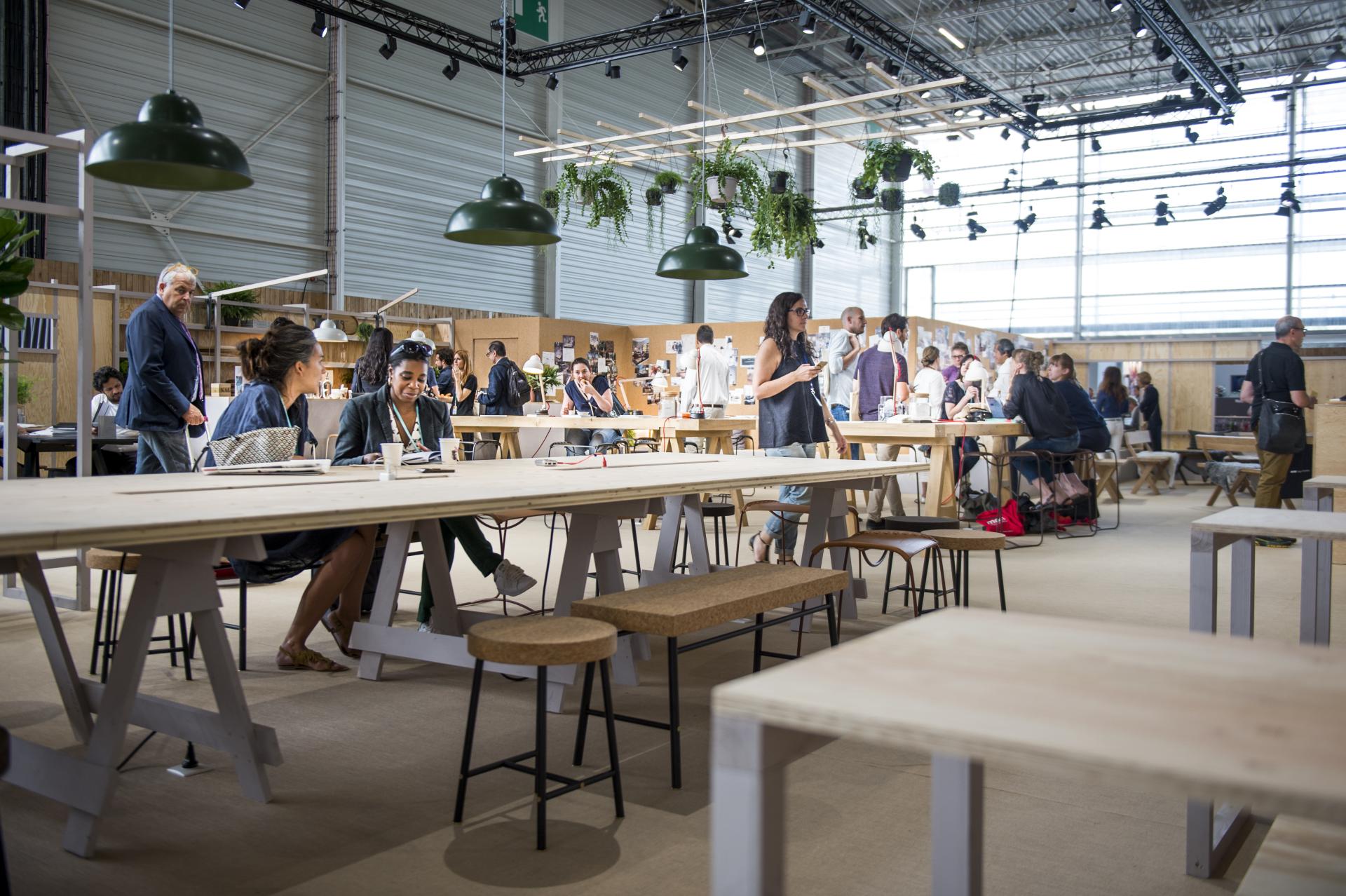 Design enthusiasts gather at a modern exhibition space in Paris, showcasing innovative furniture and decor ideas.