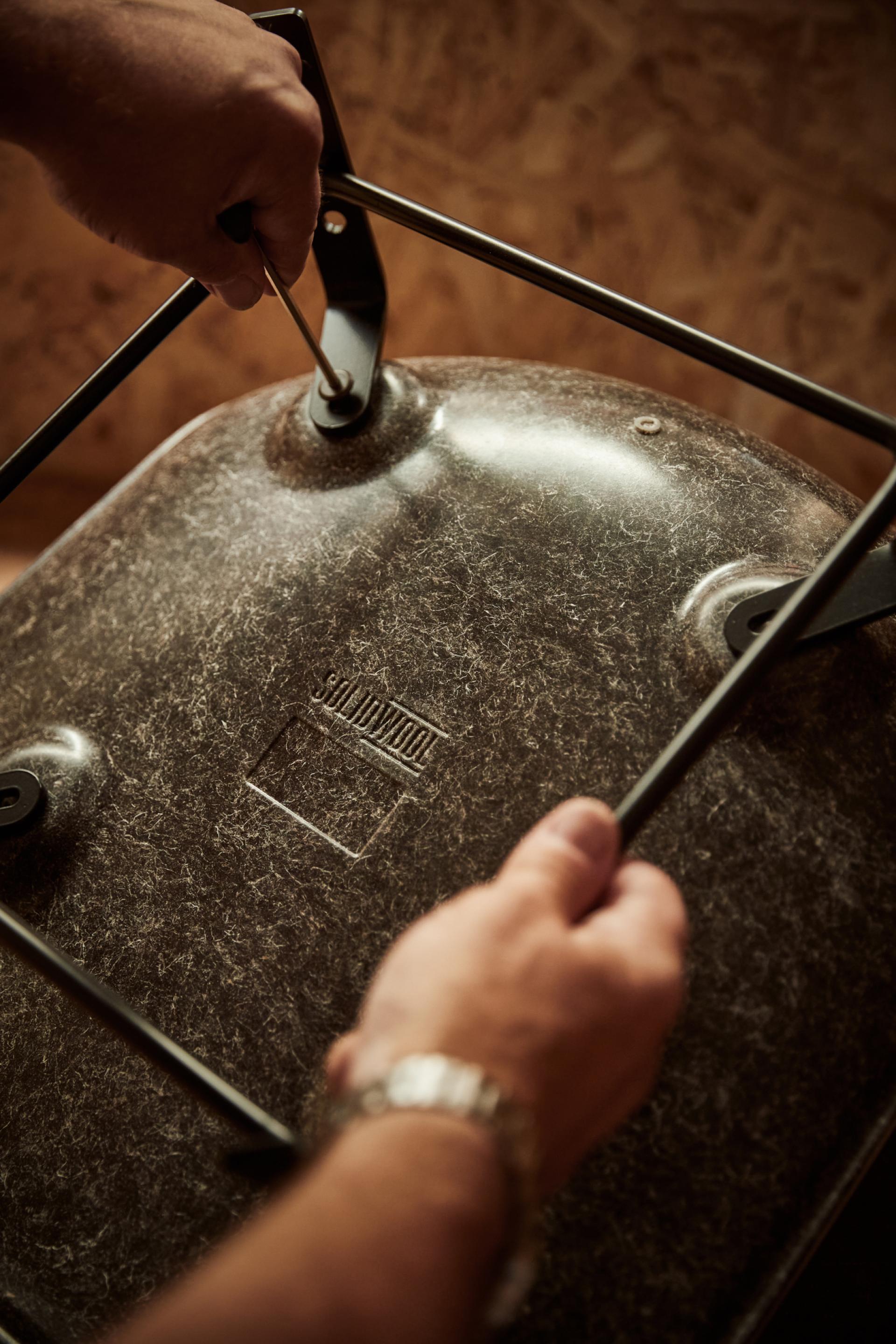 Hands assembling a Solidwool chair, showcasing the unique texture and sustainable material of this innovative furniture design.