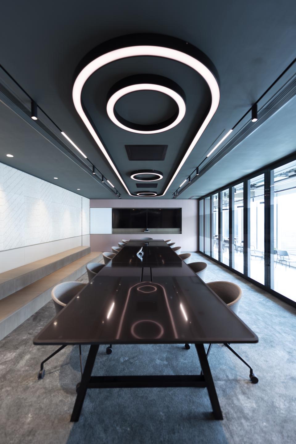 Modern conference room designed by Bean Buro for Warner Music Hong Kong, featuring sleek lighting and glass walls.