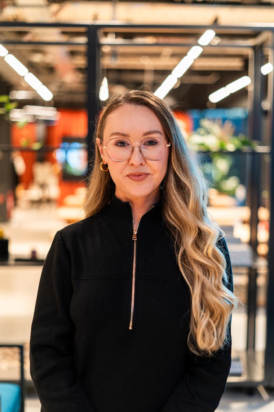 Becky Spenceley, Gensler design director, poses in a modern workspace, highlighting neurodiversity and purposeful design in the workplace.