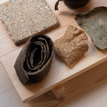 Various innovative wood materials displayed on a wooden surface, showcasing sustainable design in architecture.