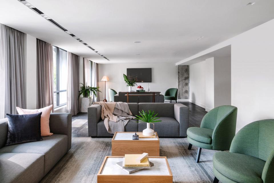 Stylish hotel lounge featuring mid-century design, pale pink accents, natural materials, and inviting seating arrangements.