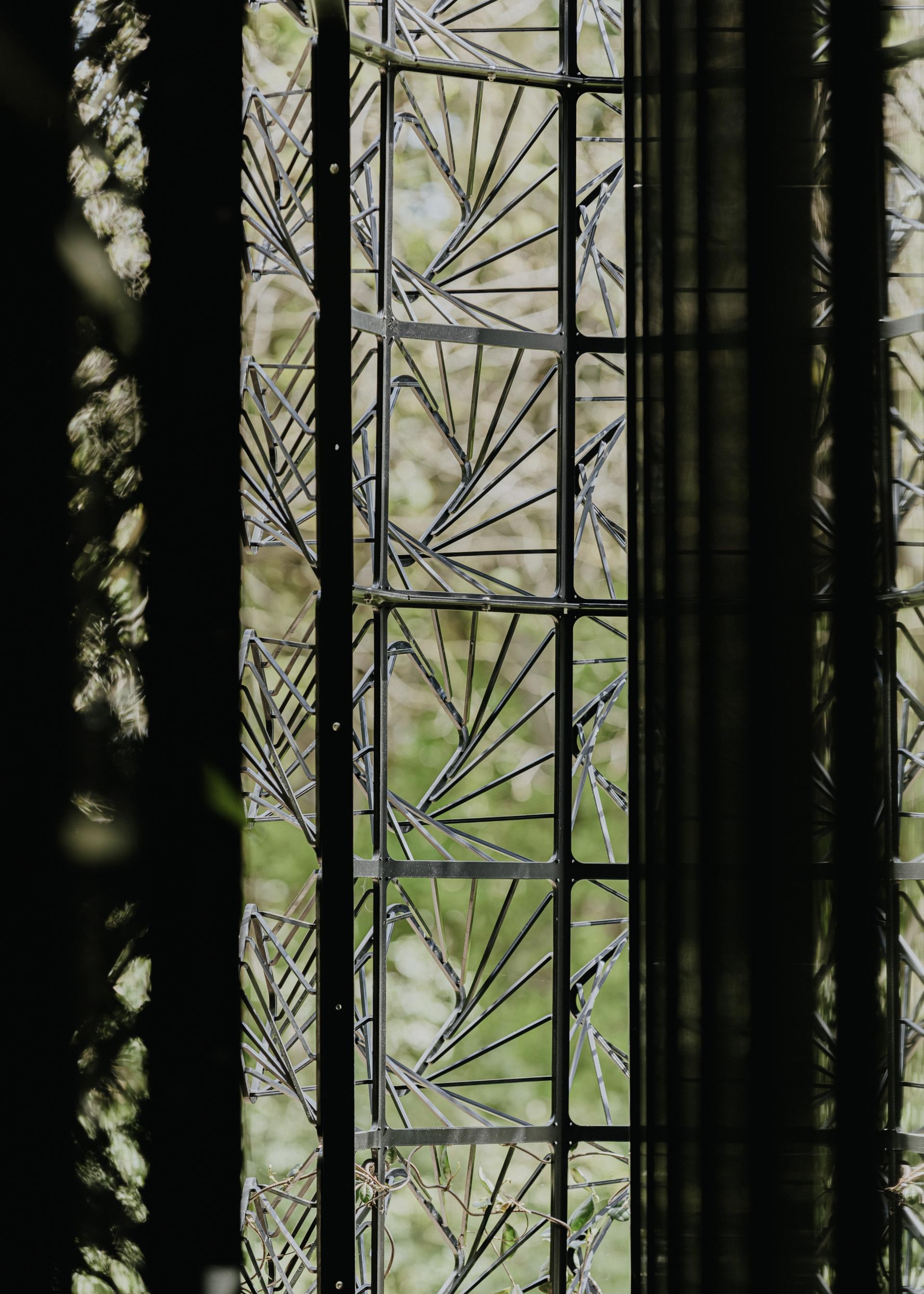 Handmade sculptural glass window with intricate patterns, showcasing the interplay of light and nature in residential design.