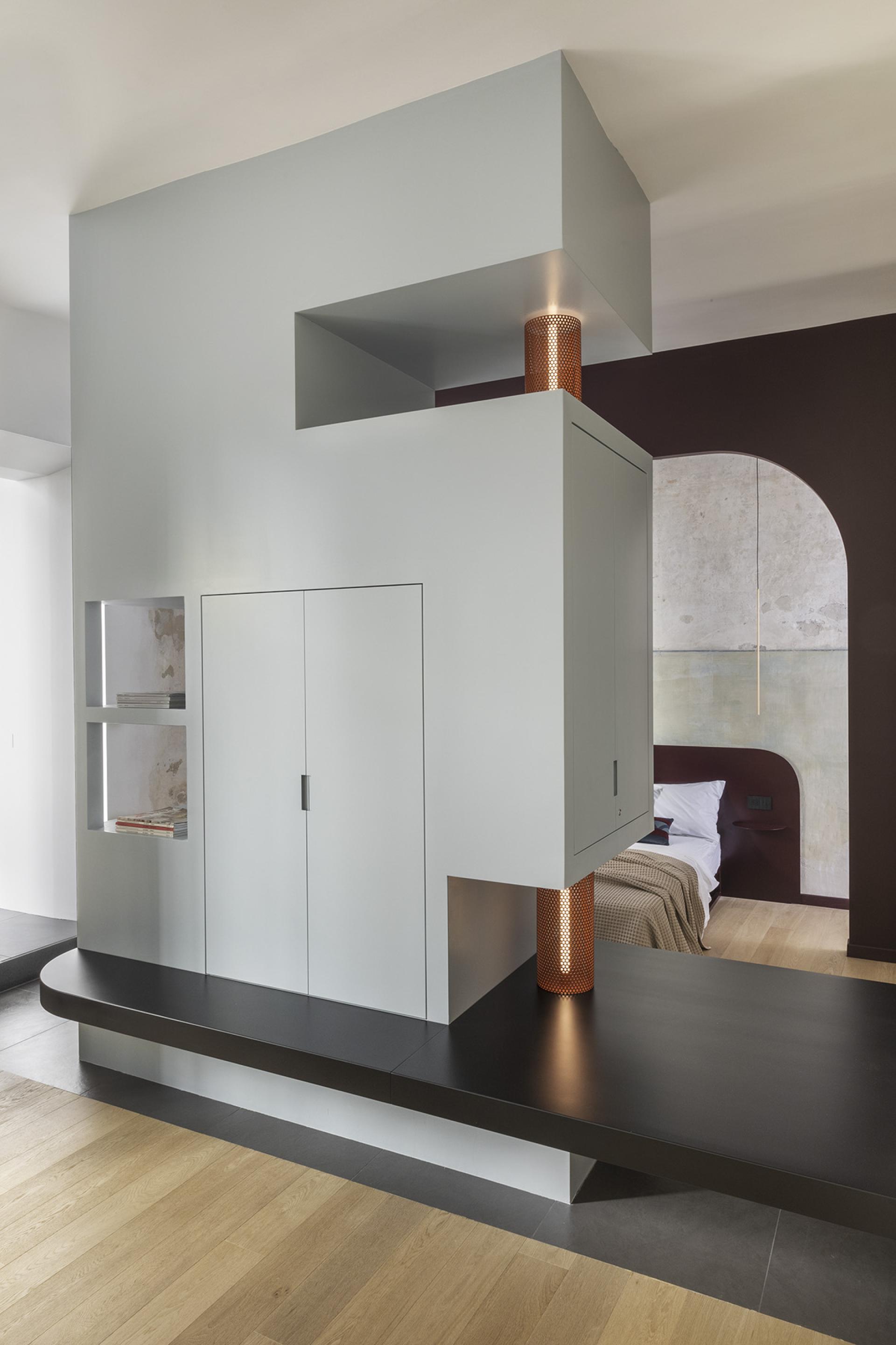 Modern minimalist design of a stylish apartment interior in Trastevere, featuring unique cabinetry and warm lighting elements.