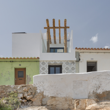 Distinctive Portuguese architecture featuring a white building with a patterned facade and sustainable design elements, reflecting Jutta Hoehn's style.