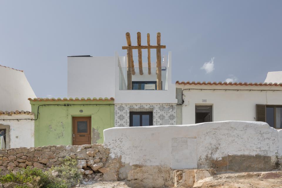 Distinctive Portuguese architecture featuring a white building with a patterned facade and sustainable design elements, reflecting Jutta Hoehn's style.