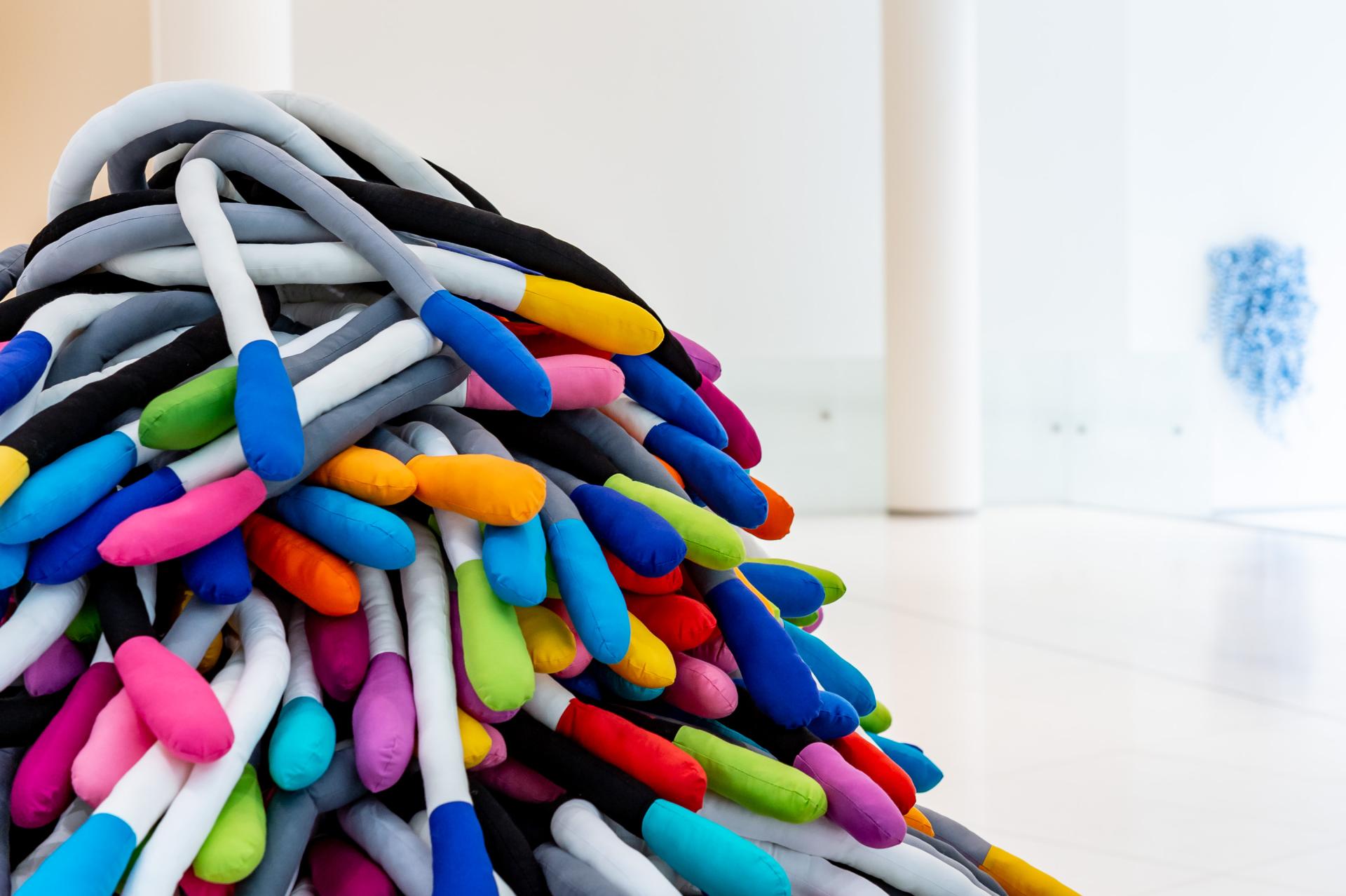 Vibrant textile sculpture by Anna Ray, showcasing colorful fabric tubes celebrating London's weaving heritage.