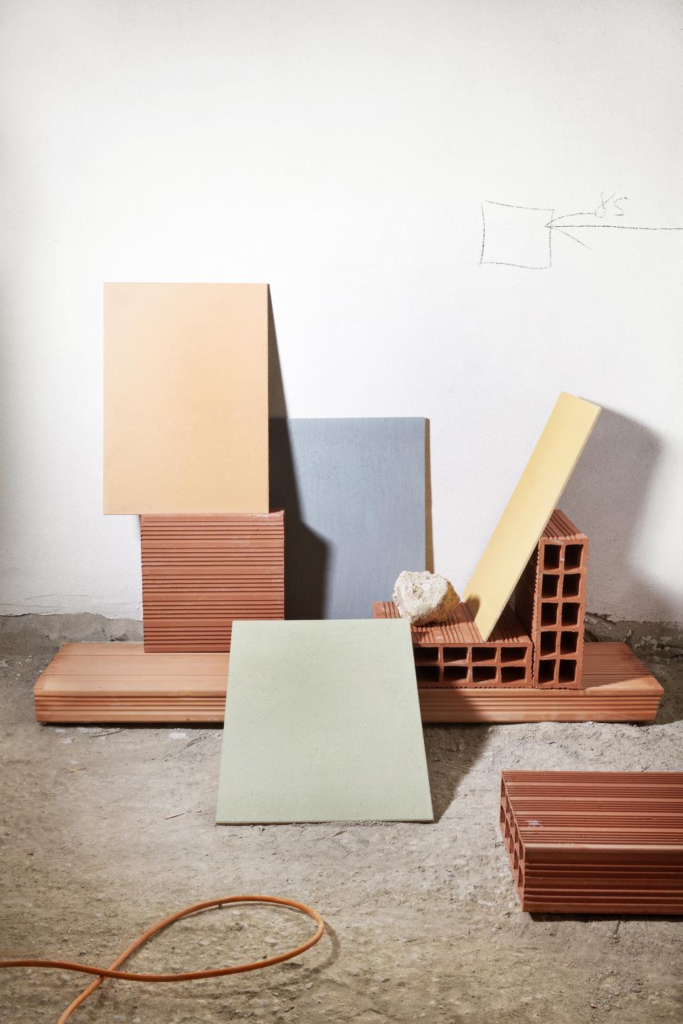 Colorful design materials, including tiles and bricks, arranged artistically for Serena Confalonieri's 13.10 Ristorante project.