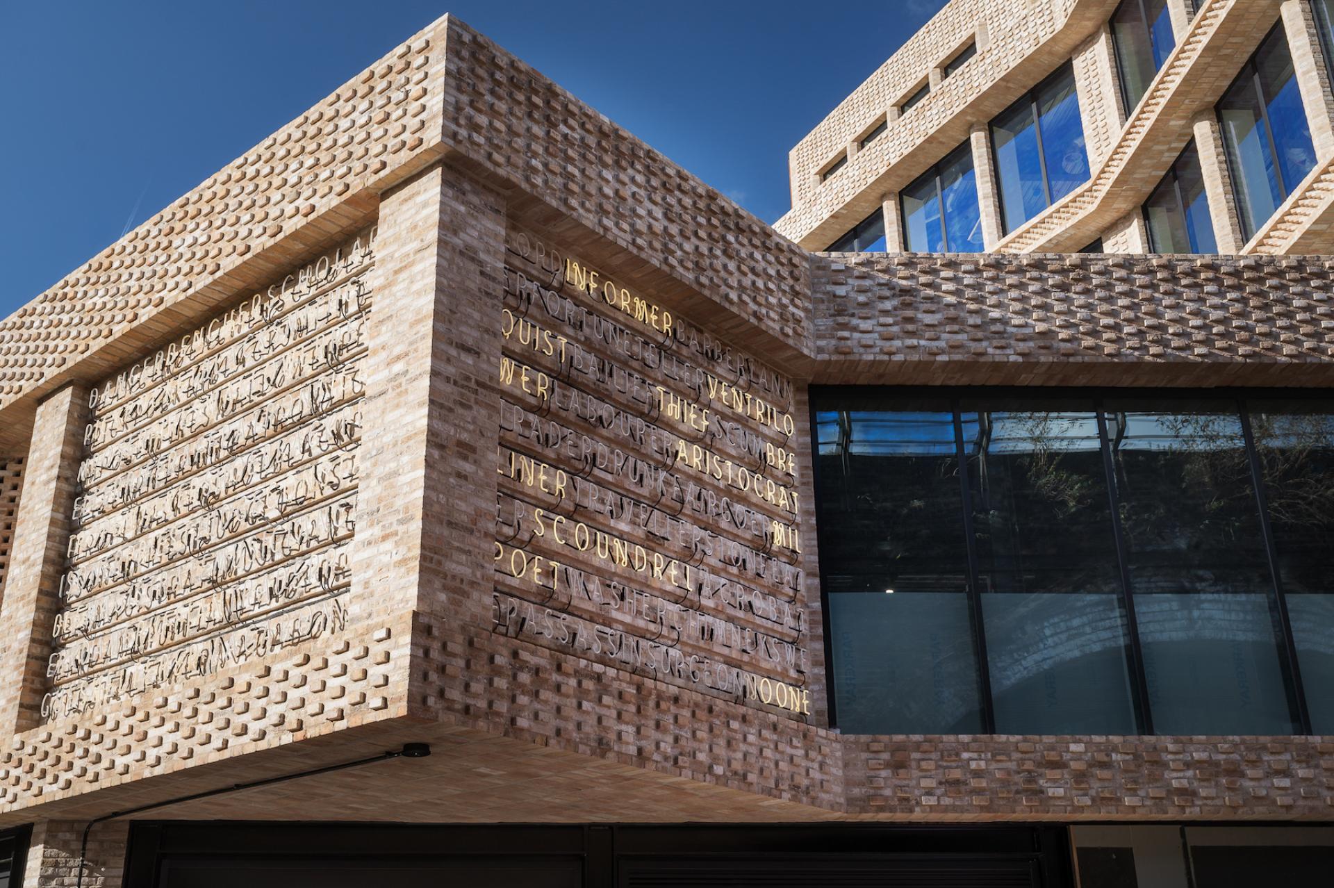 Modern architectural detail of Borough Yards featuring textured brick façade and artistic inscriptions, enhancing the cultural destination in London.