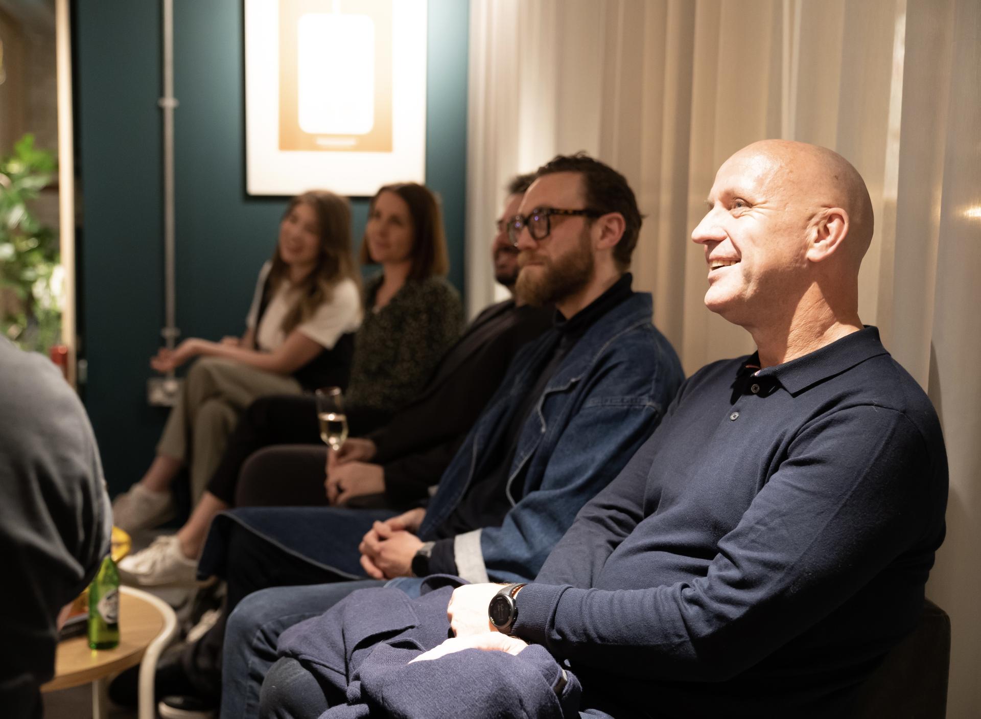 Attendees engaged in discussion at a technology seminar, reflecting the impact of advanced workplaces on collaboration and innovation.