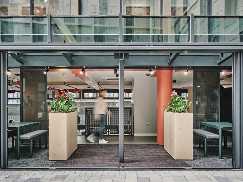 Modern student accommodation entrance at The Refinery, featuring indoor greenery and contemporary design elements.
