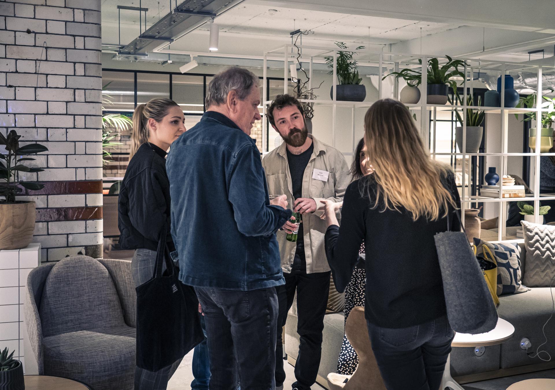 A group of professionals engaging in discussion about the future of residential design in a modern setting.
