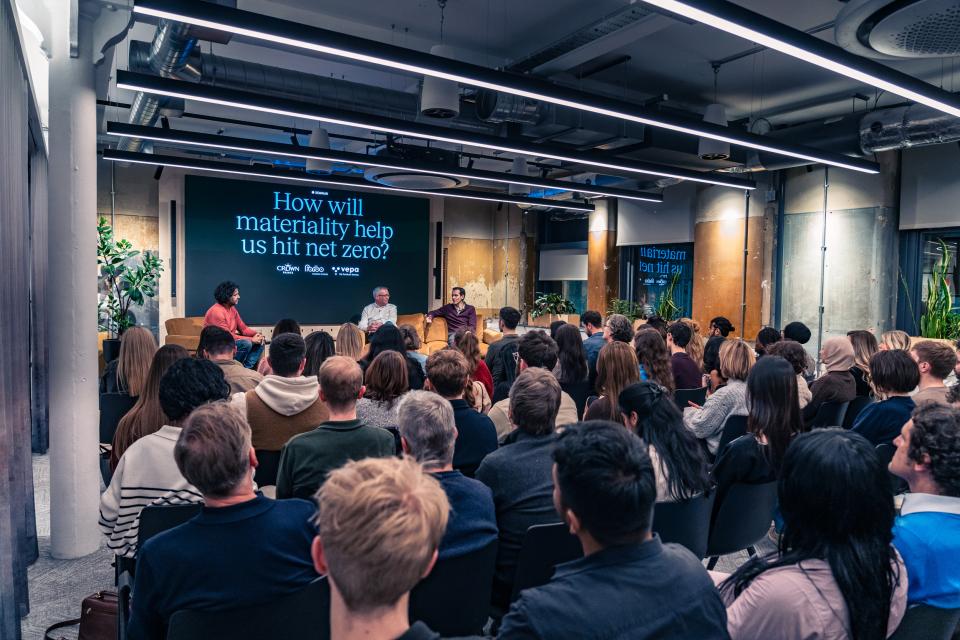 Panel discussion on materiality's role in achieving Net Zero, with an engaged audience in a modern venue.