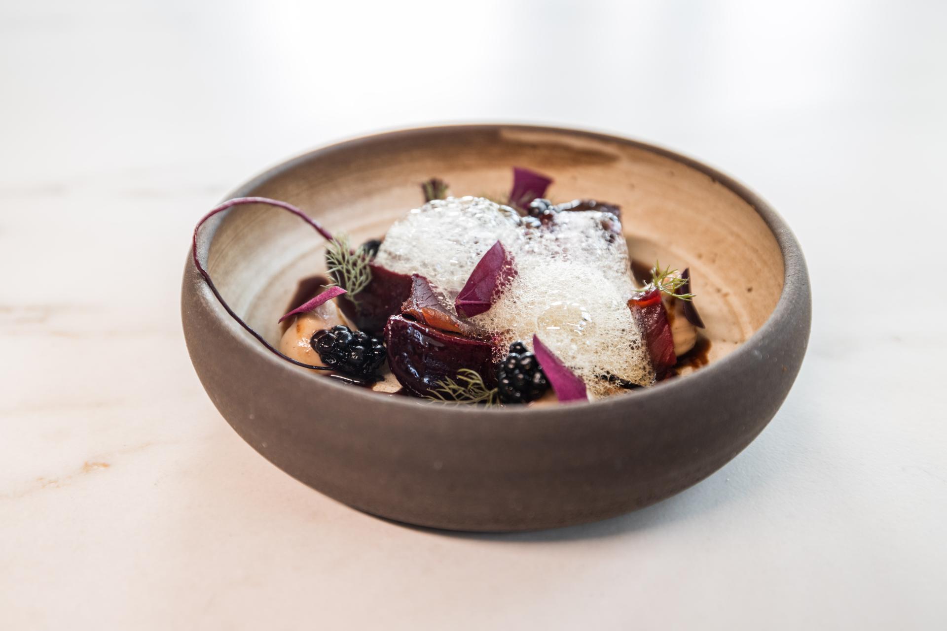 Artfully presented dessert featuring vibrant colors, textures, and garnishes at The Water House Project restaurant in East London.