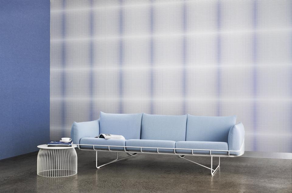 Cosy blue sofa against a stylish plaid acoustic wall, showcasing modern design and innovative sound-absorbing solutions.