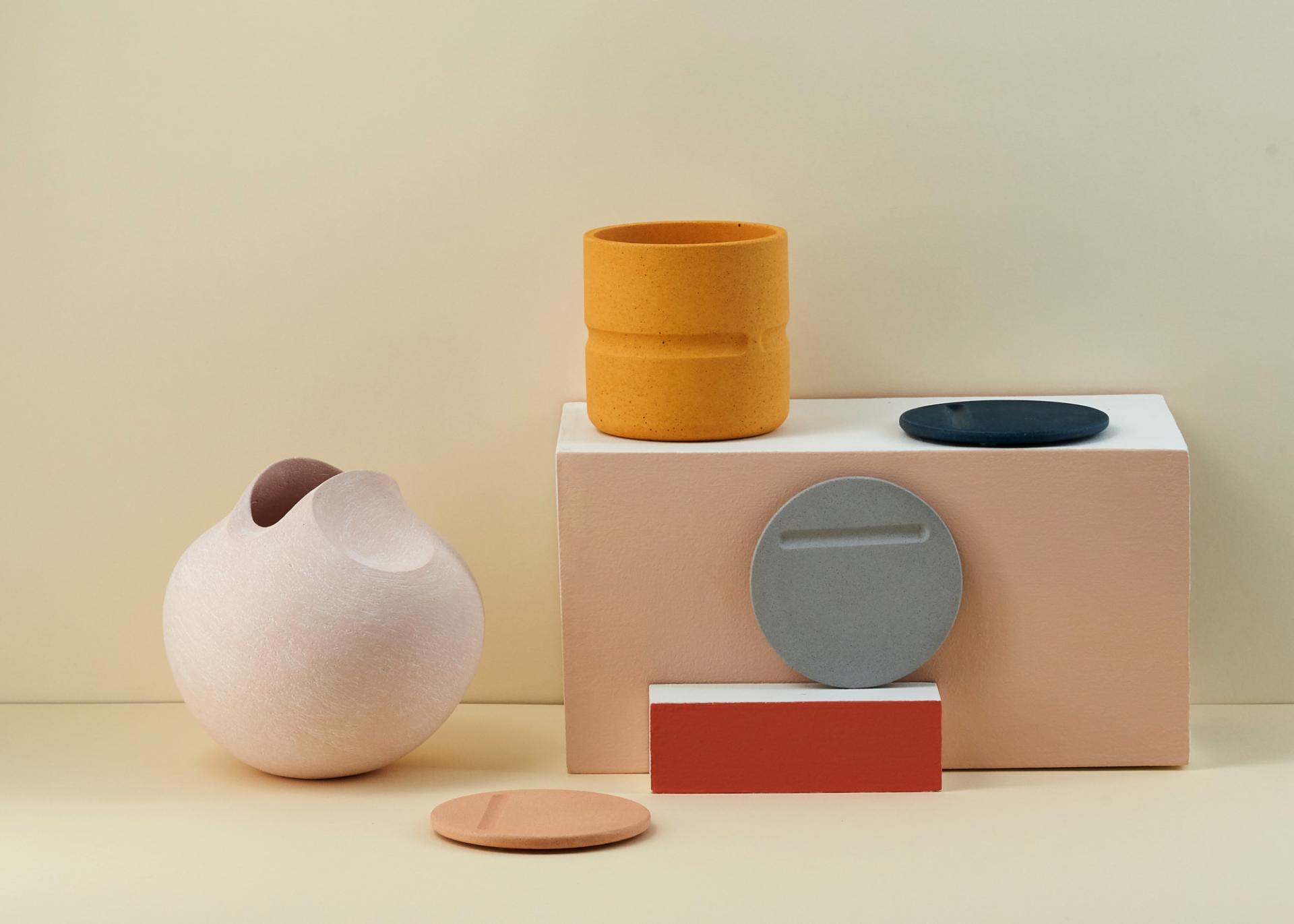 Colorful ceramic vases and plates displayed artistically, highlighting innovative designs from emerging talent at New Designers 2019.