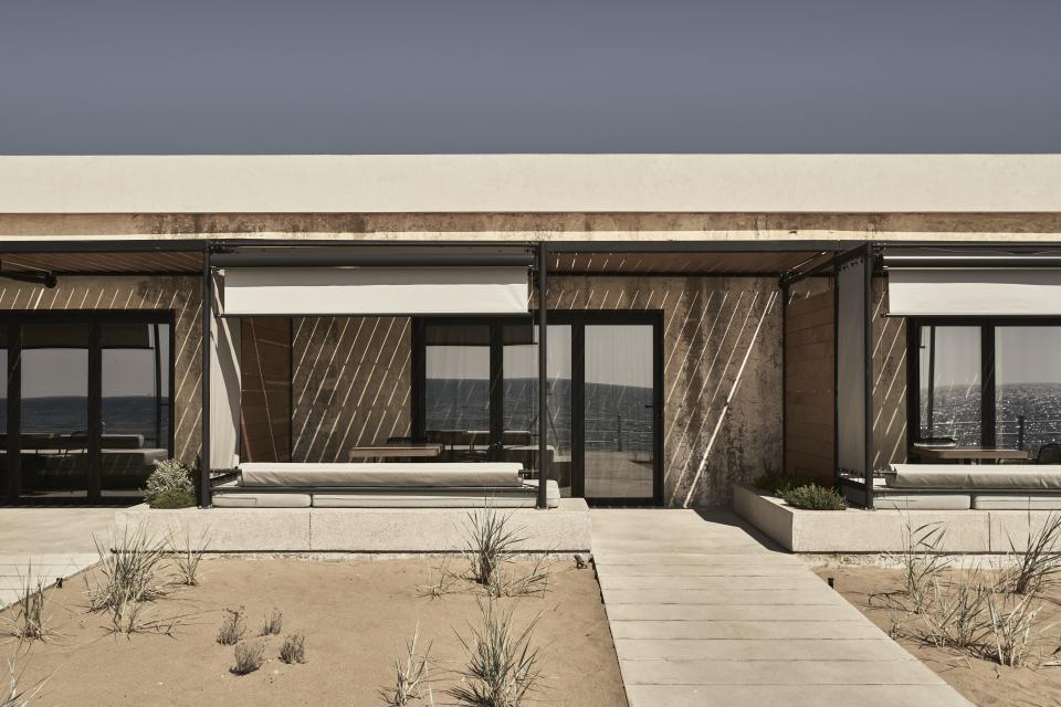 Chic resort exterior featuring modern design, large windows, and ocean views on the Peloponnese peninsula.