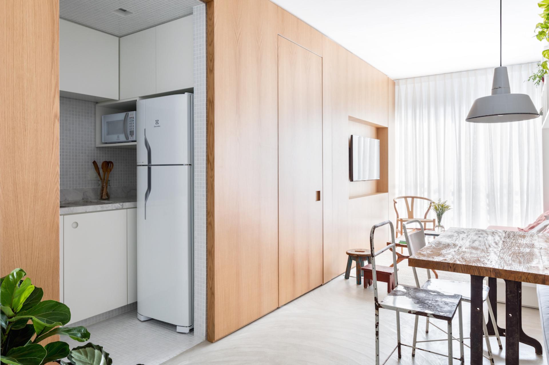 Compact apartment interior designed by Leandro Garcia, showcasing a modern kitchen and dining area with natural light.