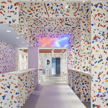 A brightly colored interior of an Amsterdam eyewear store featuring fully recycled materials and modern design elements.