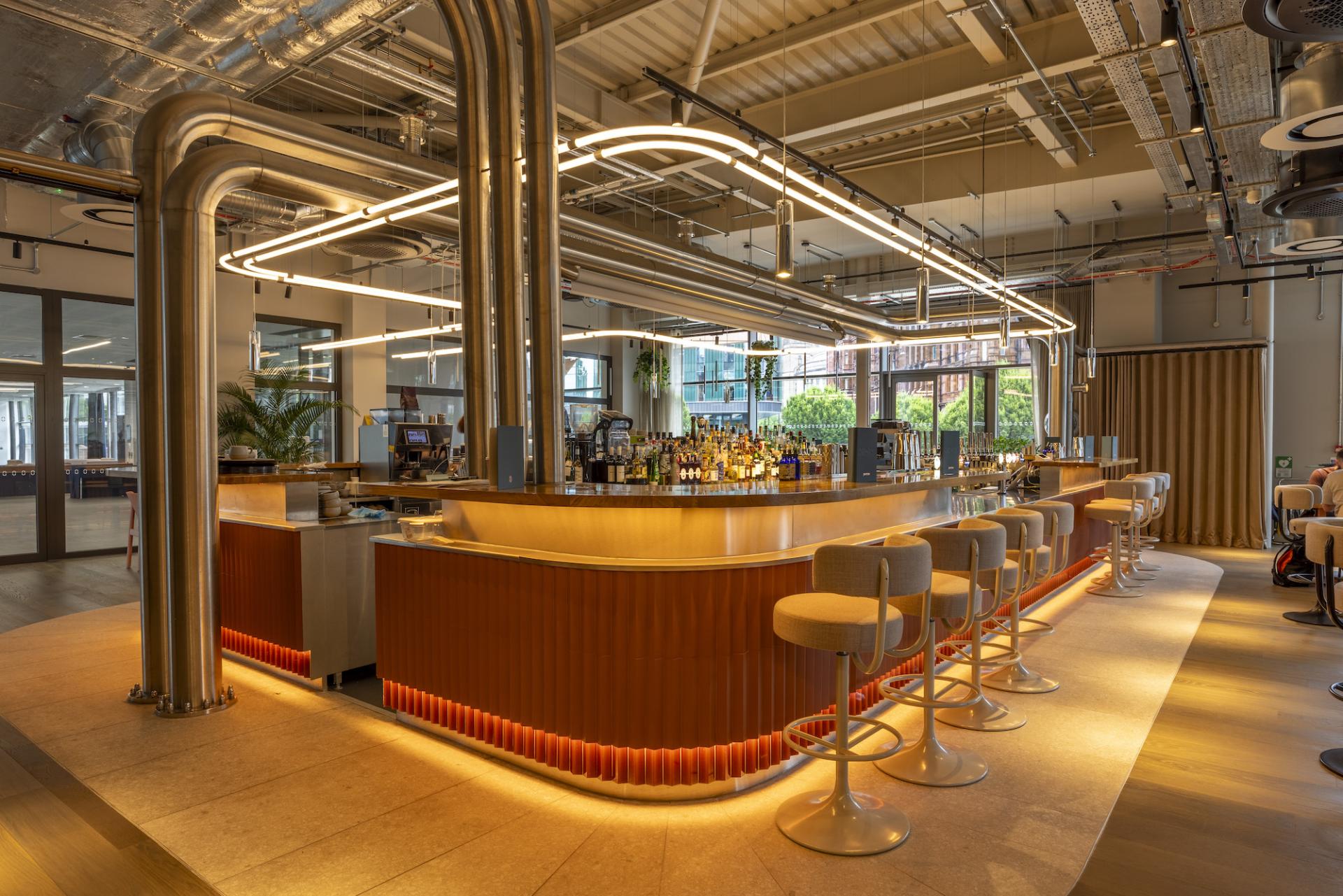 Modern bar interior at Junction, Manchester Central, featuring sleek design, LED lighting, and seating, perfect for social gatherings.