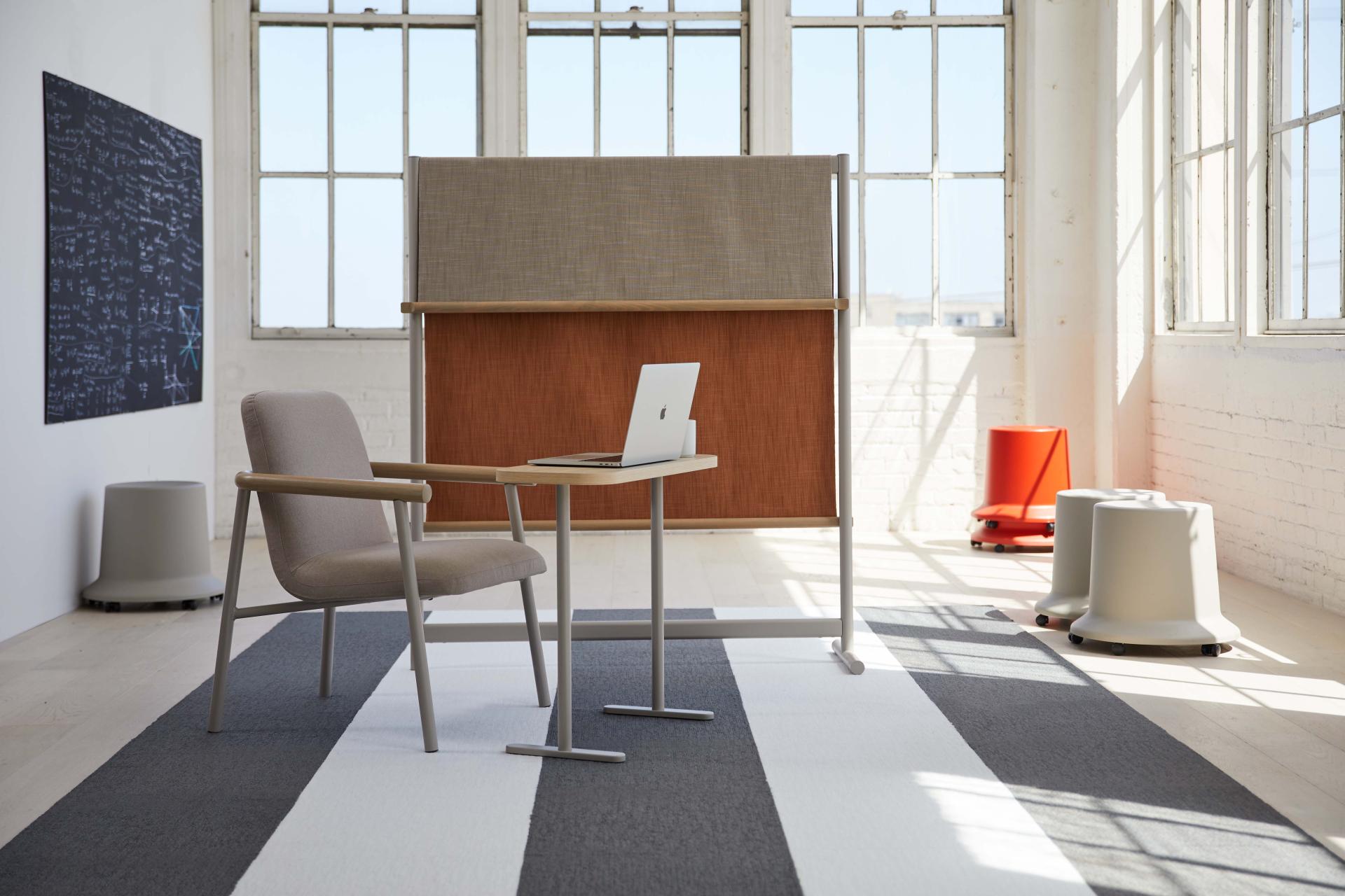 Stylish workspace featuring Pearson Lloyd's Routes furniture, including a desk, chair, and privacy screen in a bright setting.