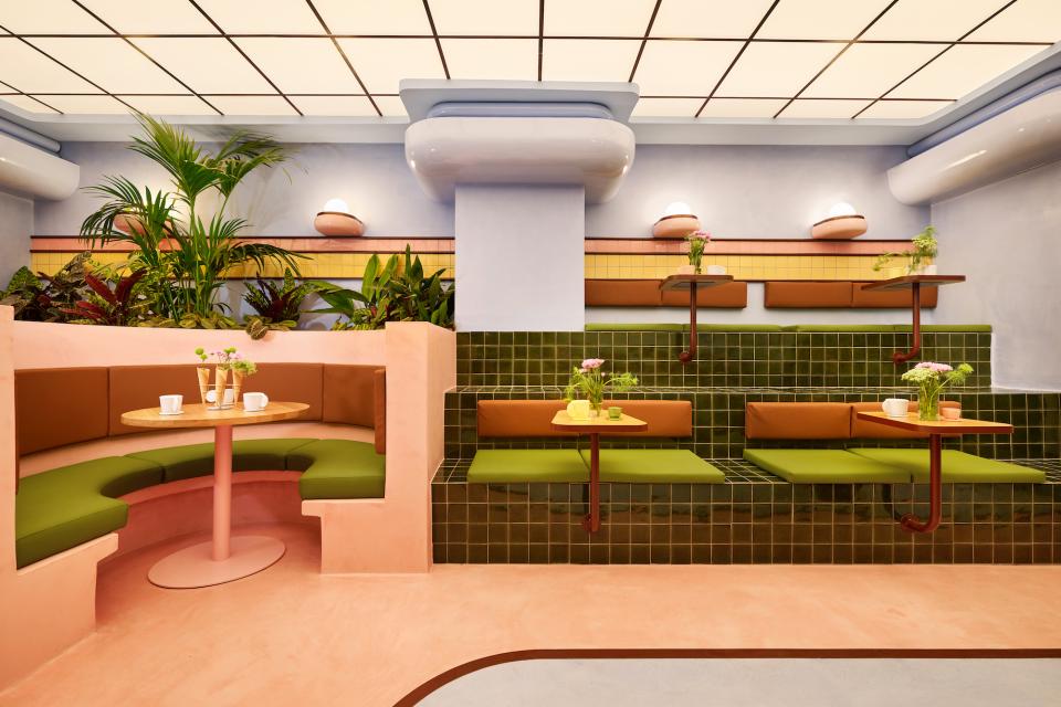 Colorful interior of a modern ice cream parlour featuring Art Deco-inspired design, plants, and cozy seating.