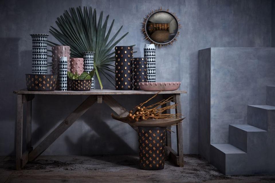 Colorful vases and decorative objects arranged on a wooden table, showcasing contemporary Middle Eastern design aesthetics.