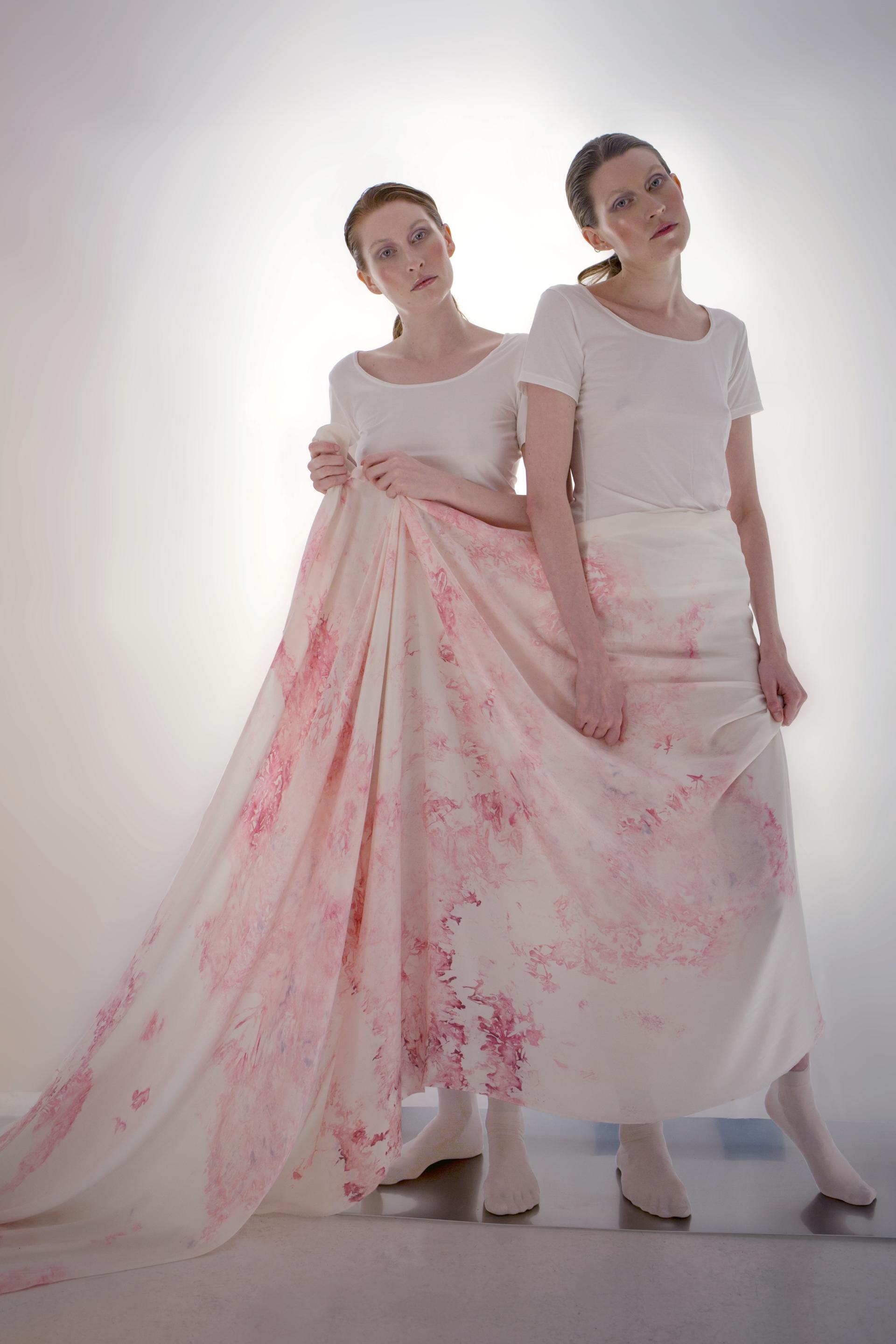 Models showcase biodesign fashion with pink-patterned fabric, emphasizing sustainability and innovative materials in modern design.