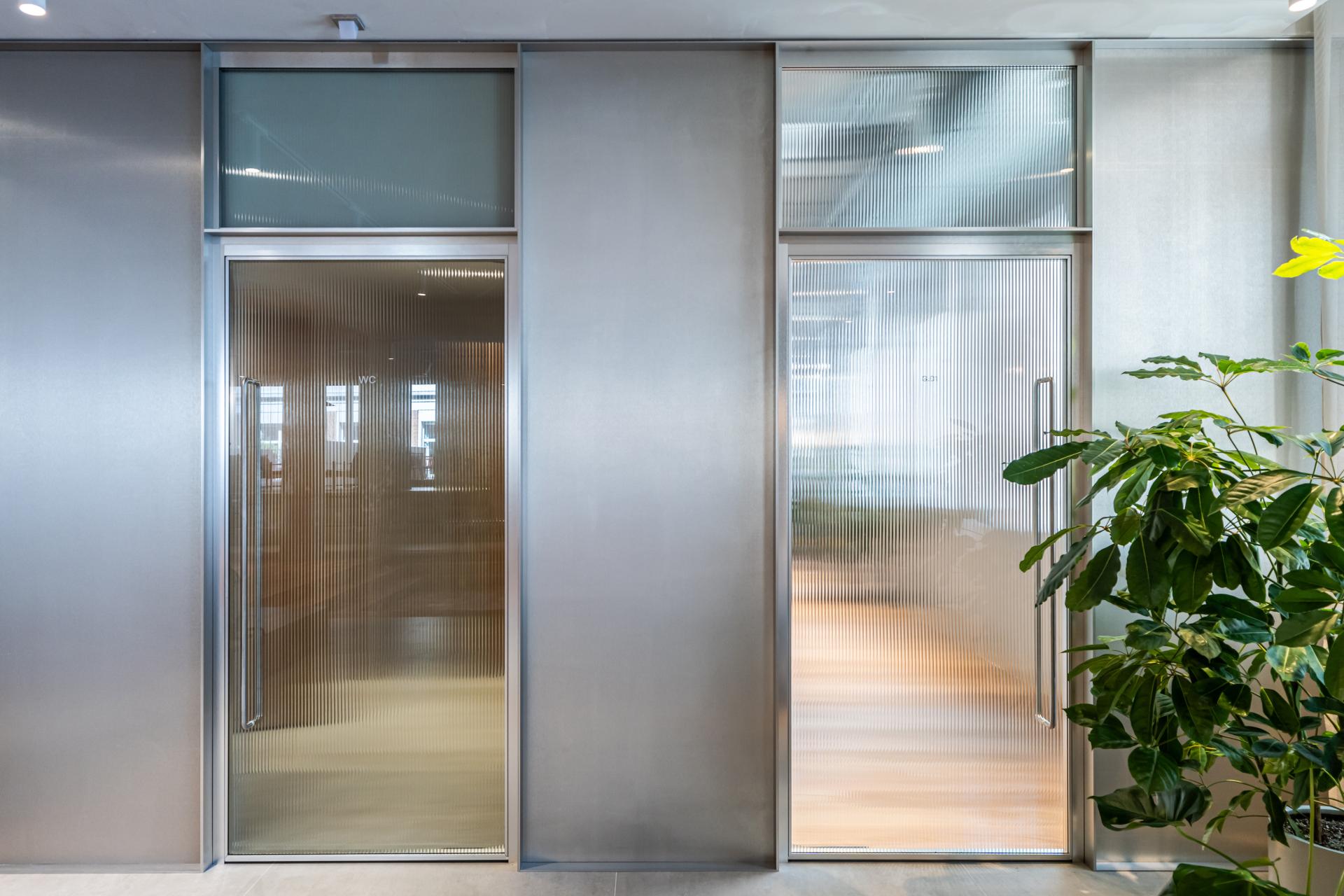 Stylish glass doors leading to workspace areas at Fora in Holborn, showcasing a modern, wellbeing-focused design.