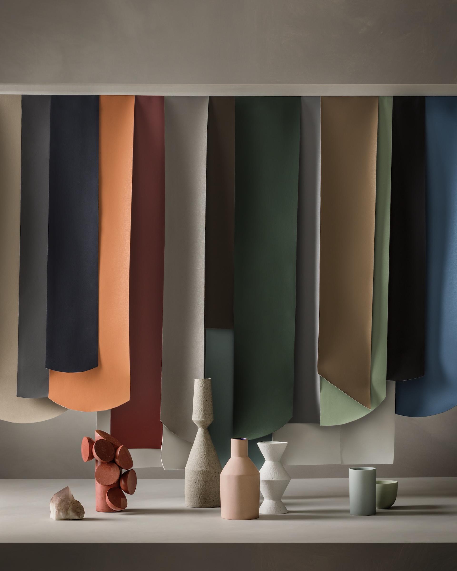 Volar Bio range by Ultrafabrics featuring earthy color fabrics with decorative vases and stones on display.