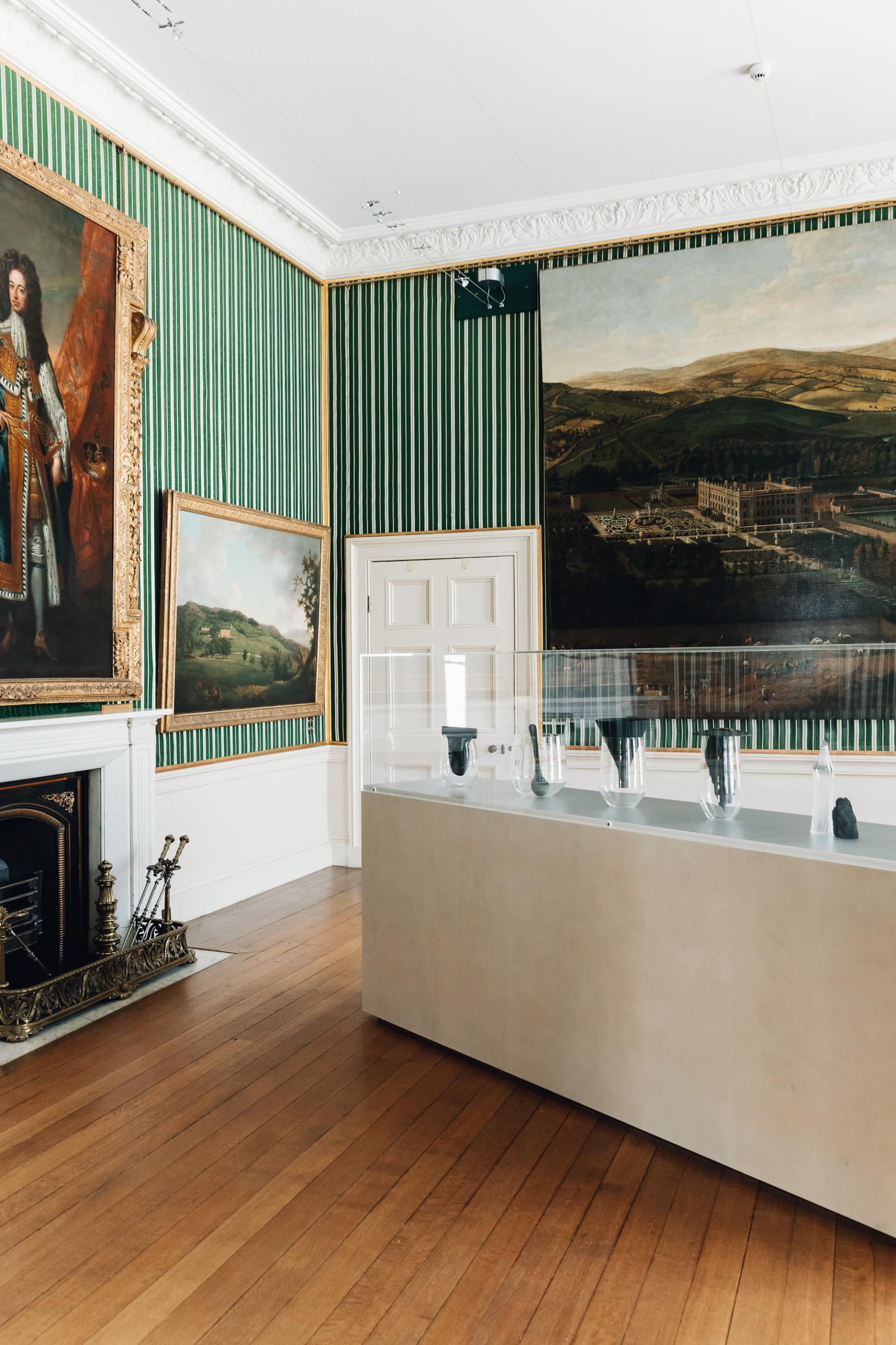 Exhibition space at Chatsworth House featuring artwork, historic paintings, and contemporary glass sculptures on display.