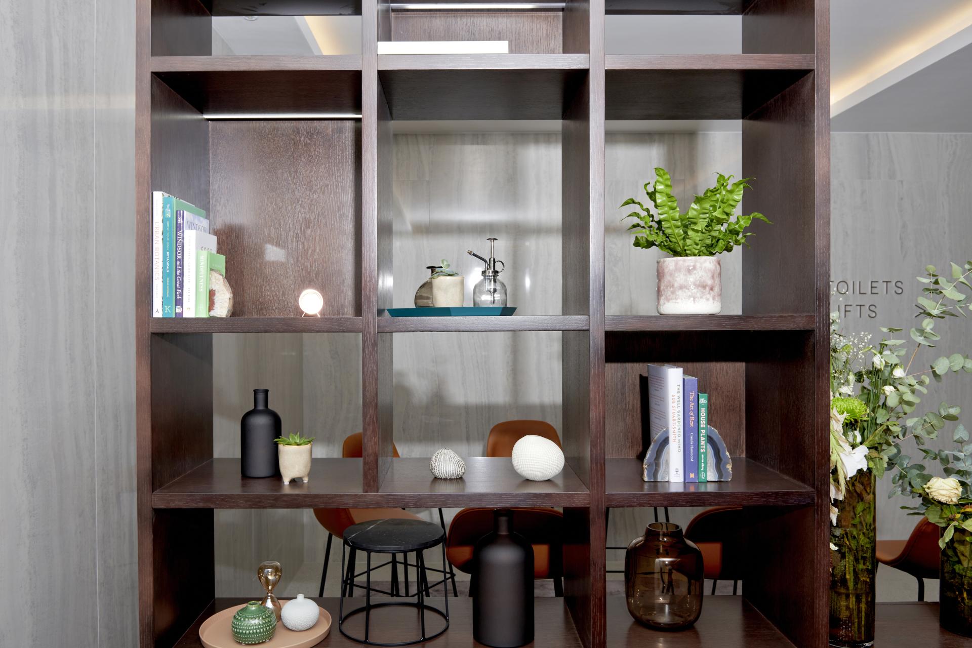 Elegant interior design featuring a wooden shelving unit with decorative plants, books, and accessories at One Victoria Street, Windsor.