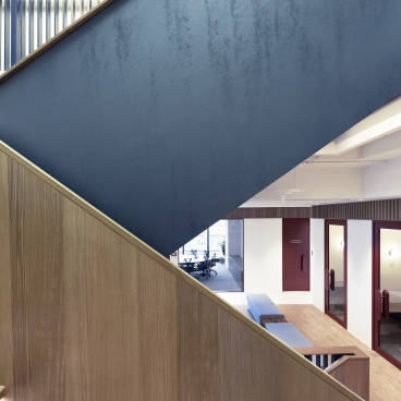 Stunning internal staircase design featuring a mix of blue and wooden elements in Bean Buro's innovative workspace.