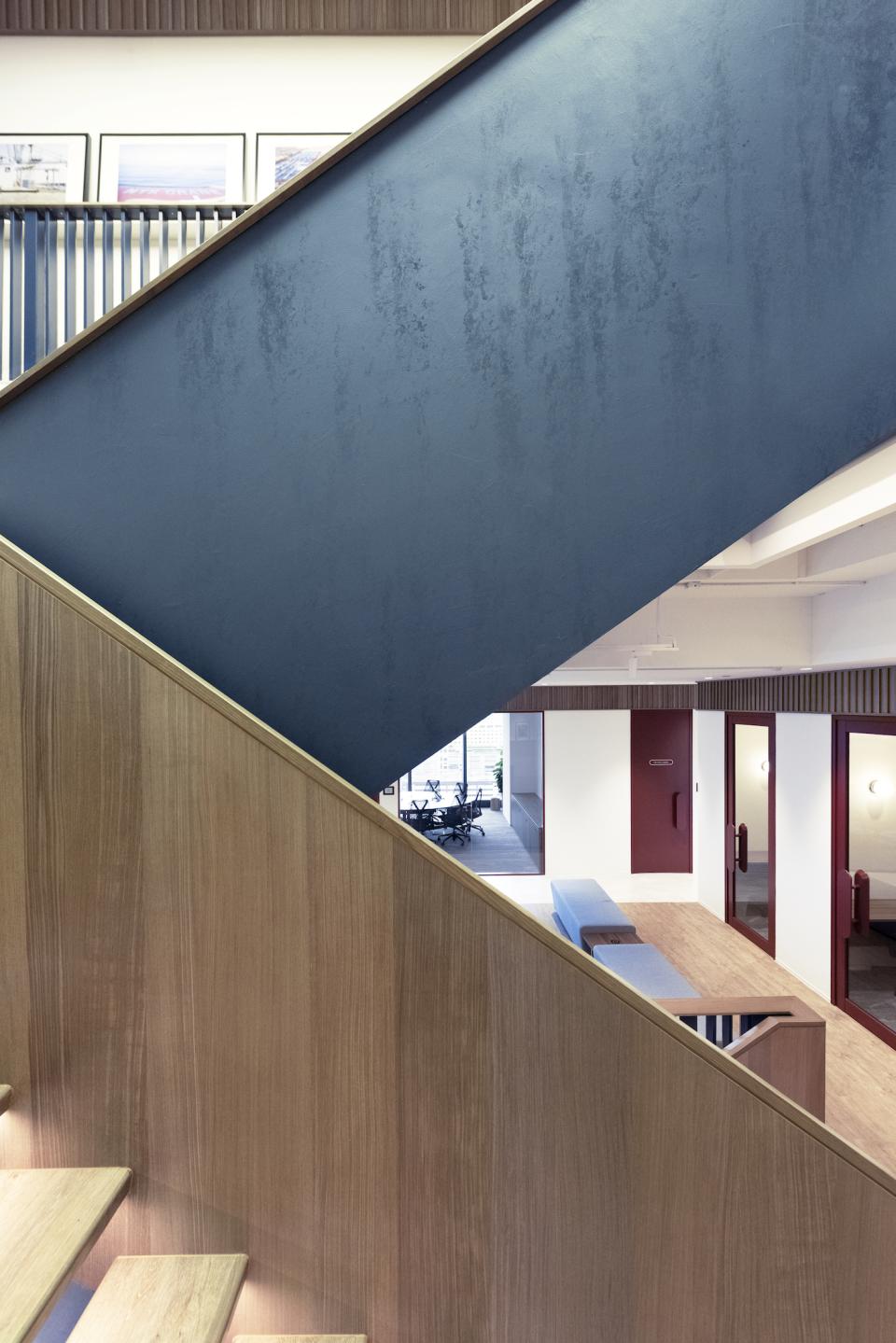 Stunning internal staircase design featuring a mix of blue and wooden elements in Bean Buro's innovative workspace.
