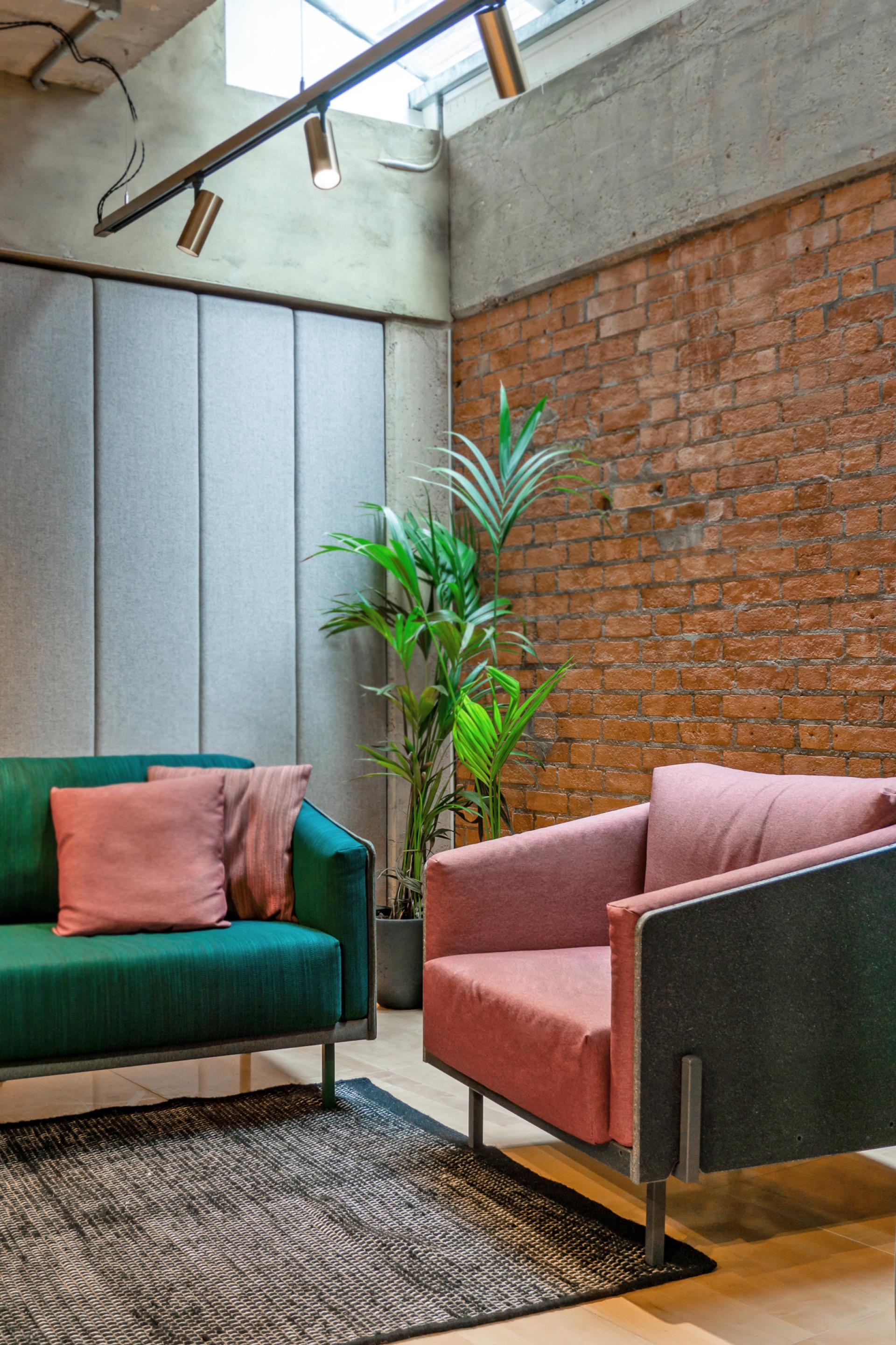 Stylish green and pink seating arrangements in a modern, sustainable interior design setting at Material Source Studio, Manchester.